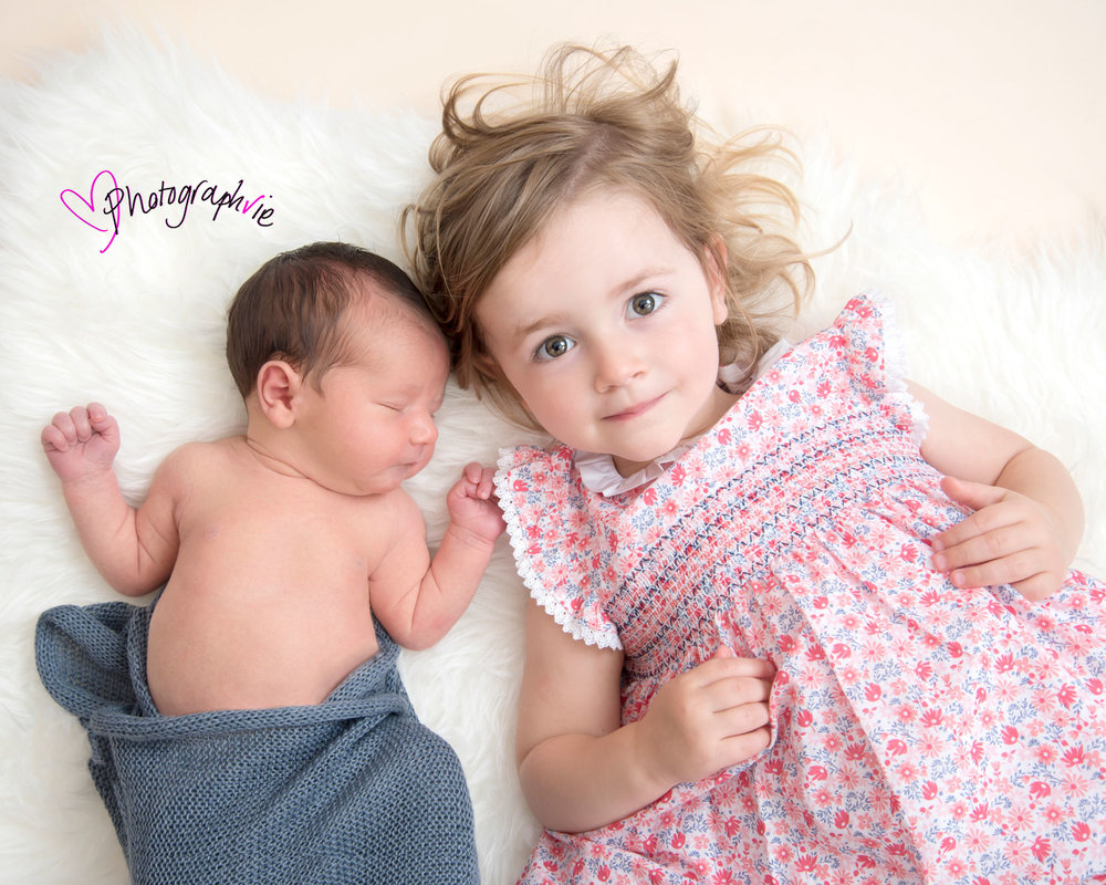 Newborn_Baby_photography_Ely_Cambridgeshire-baby-finley-lying-on-back-with-sister.jpg