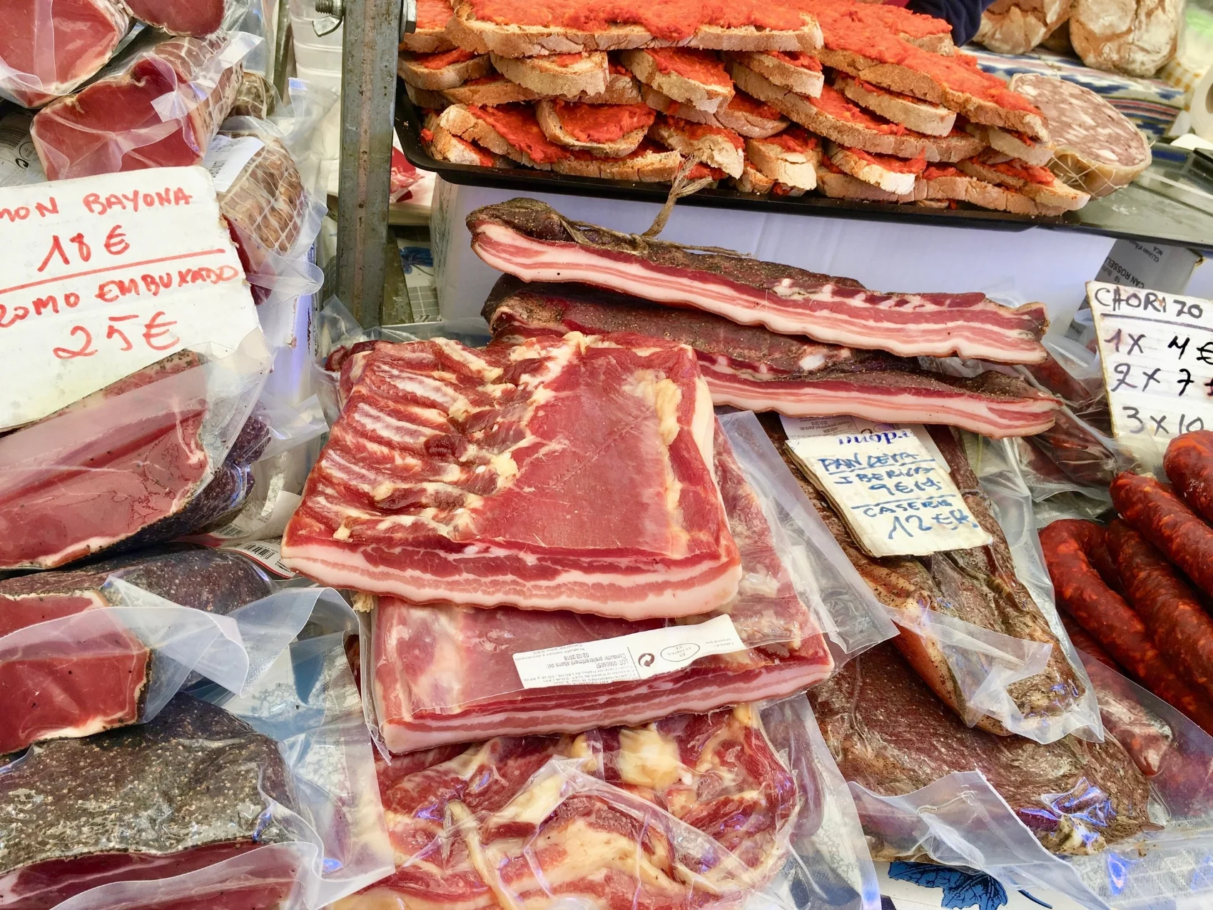 Various Spanish Cured Meats including the Sobrassada on the top spread over sliced bread.