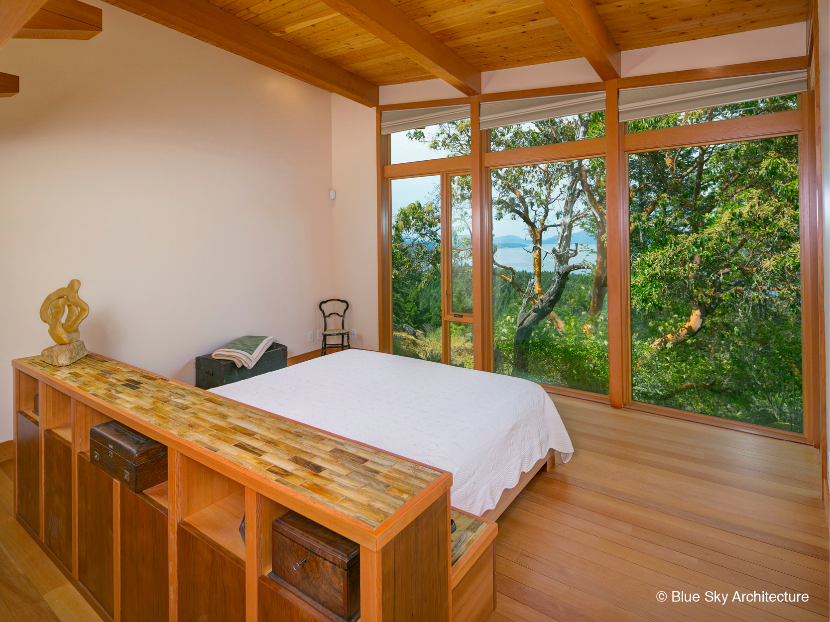 Bedroom with floor to ceiling windows and forest views