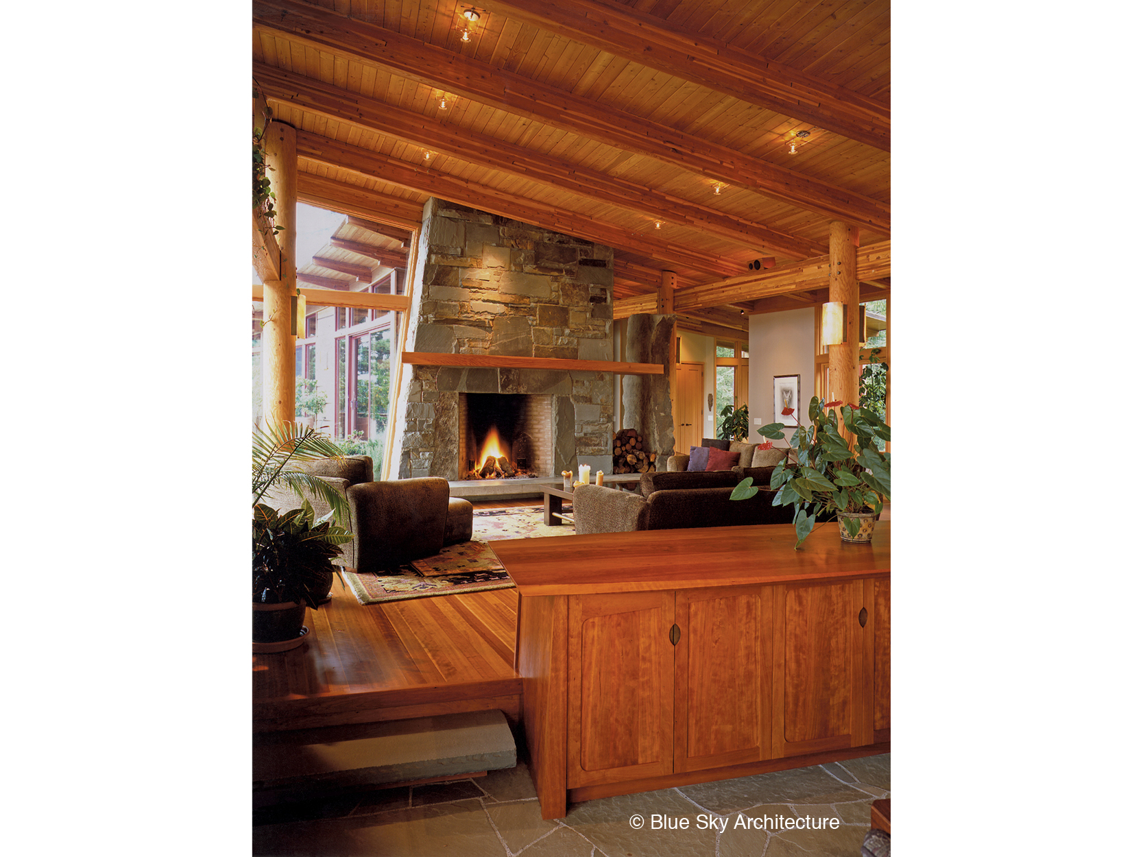 Sandstone slab fireplace with wood rafter ceiling in Hill House
