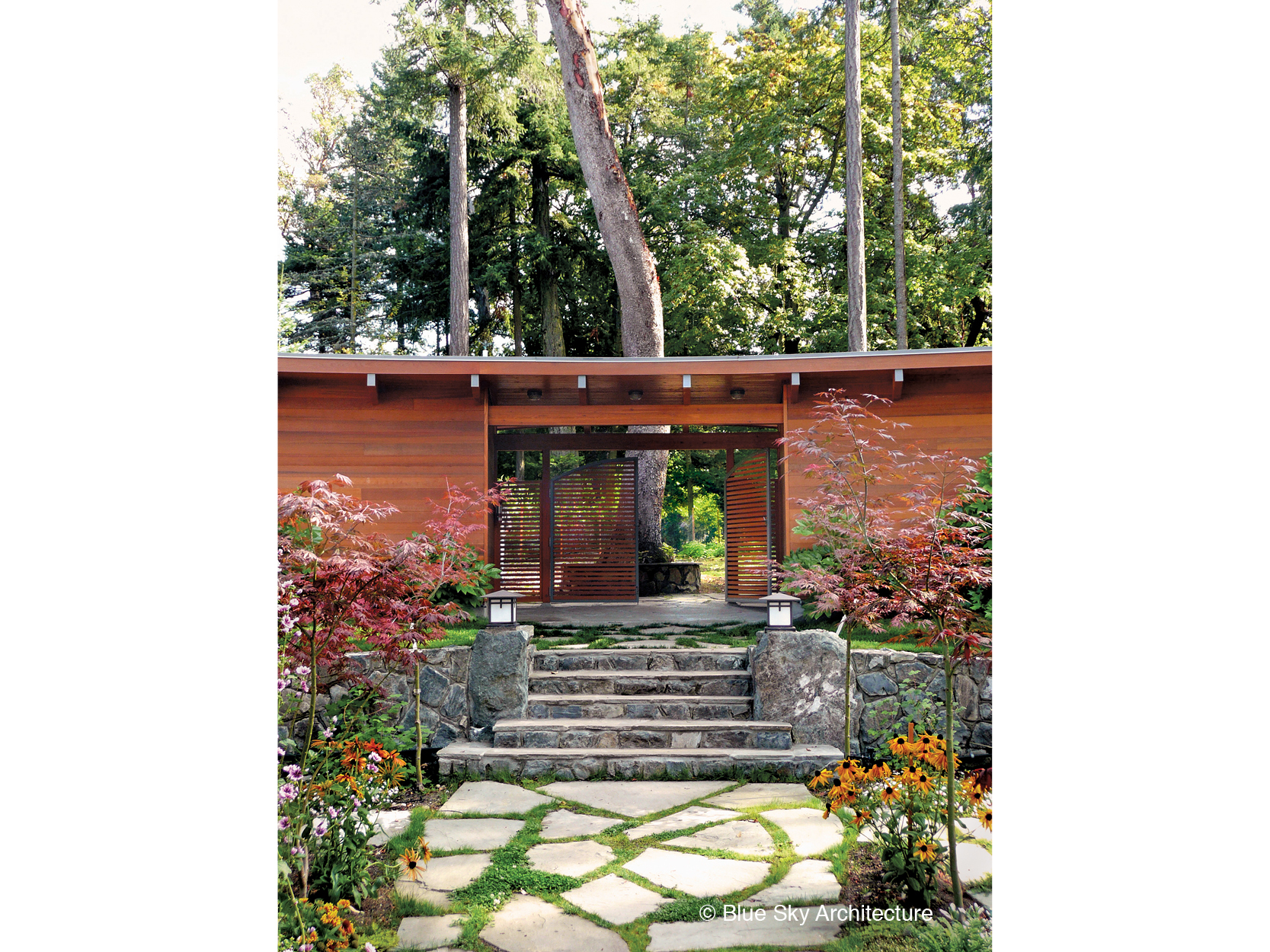 Wood gate and stone steps in the garden courtyard of Booklovers House