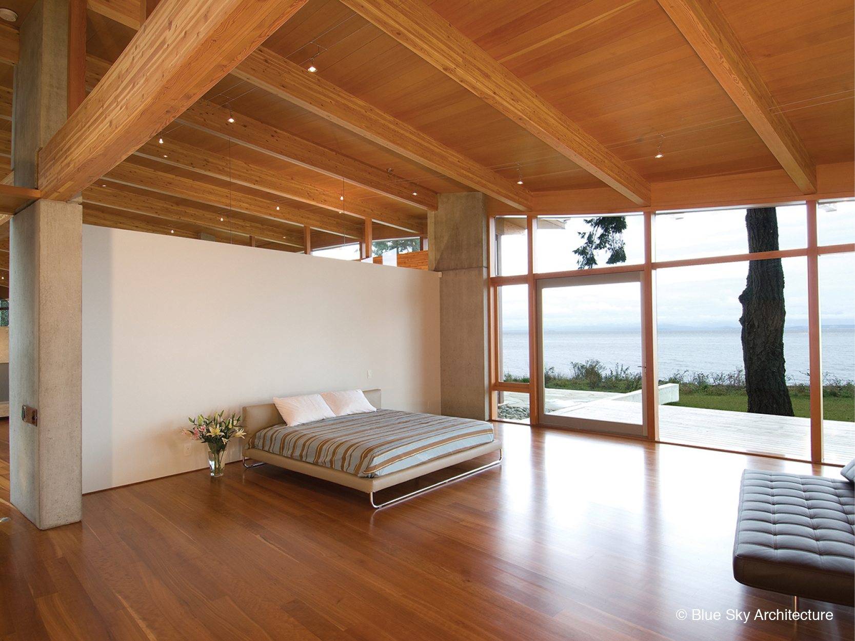 Wood rafters and natural lighting in a minimalist bedroom