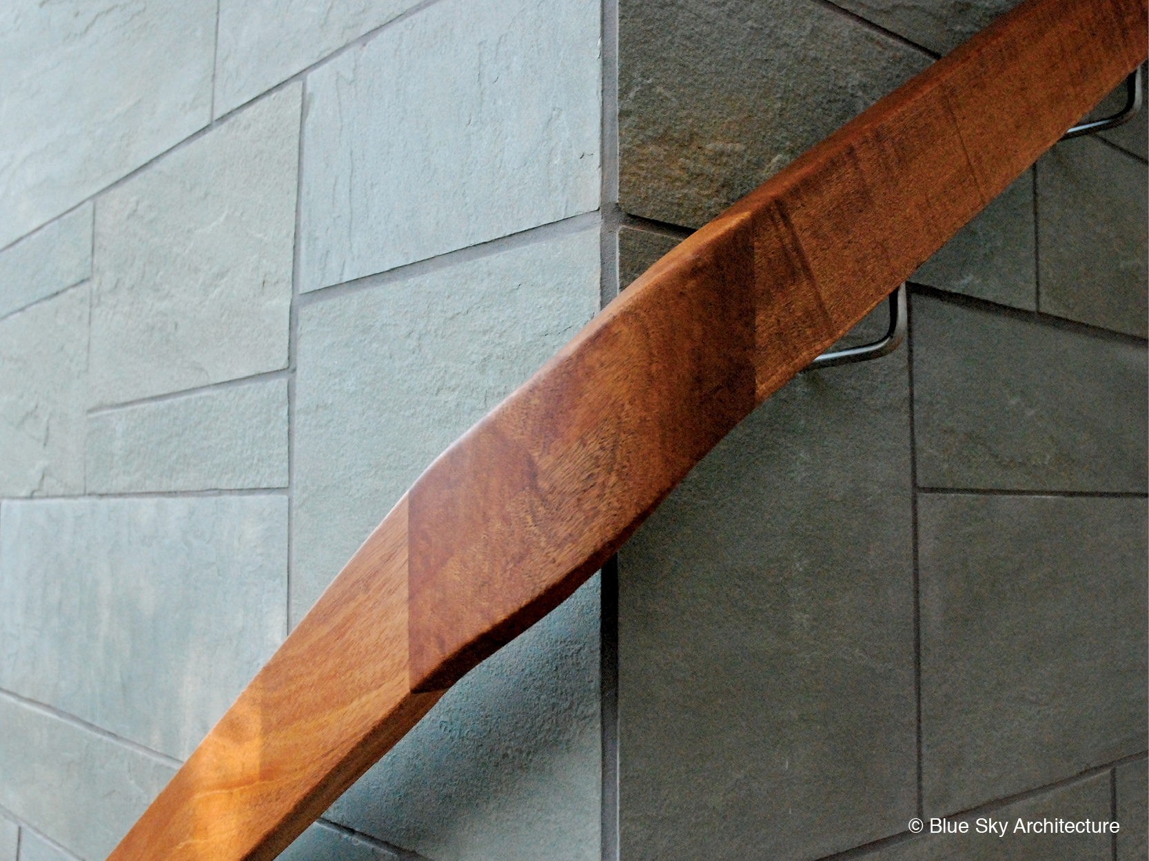 Wood handrail wraps around the slate walls of Ridge House