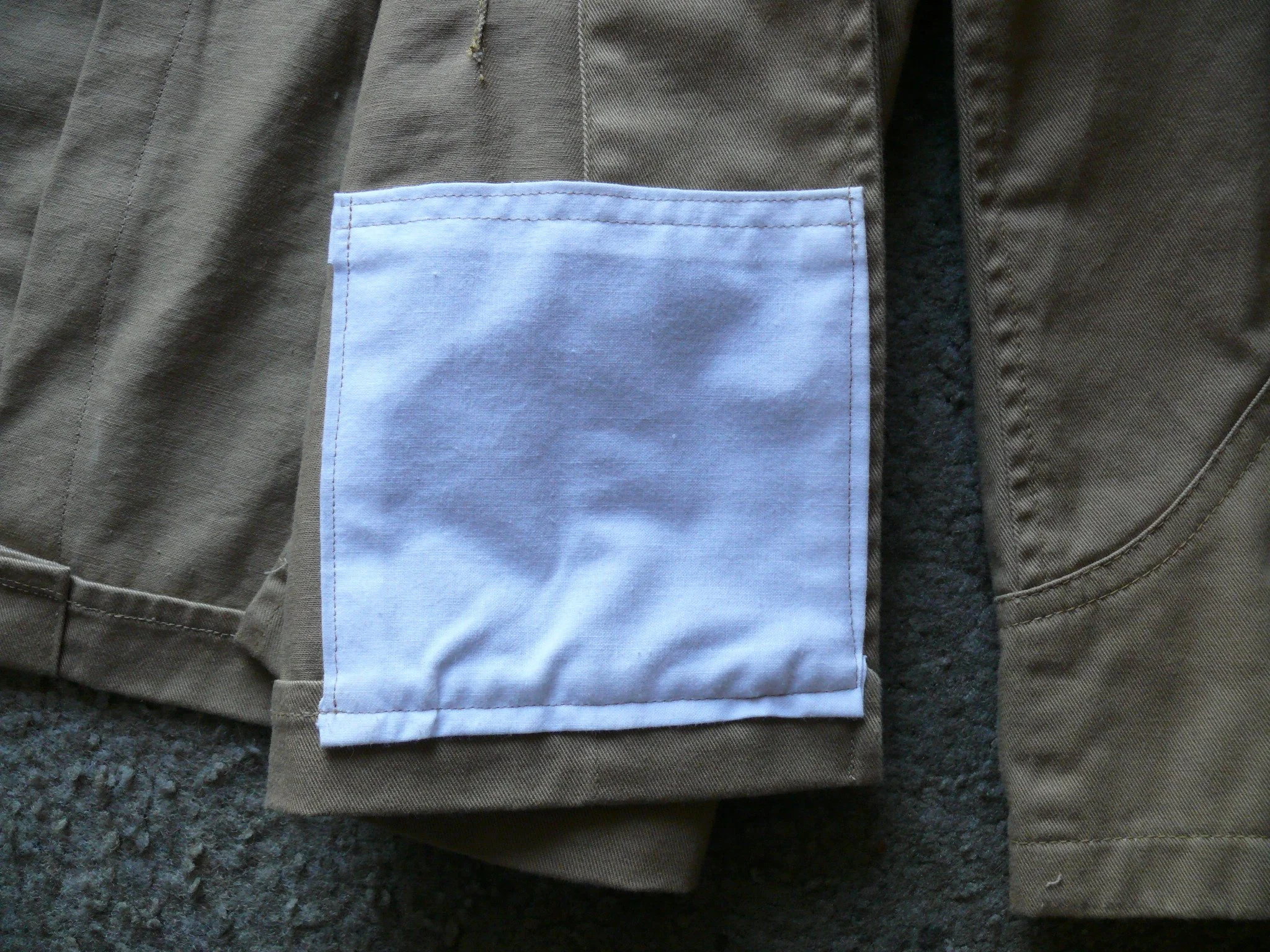 The new pocket topstitched into the inside of the tunic. The stitching of the pockets to the inside of the tunic shows through to the outside and that is correct. We see that in historic examples.