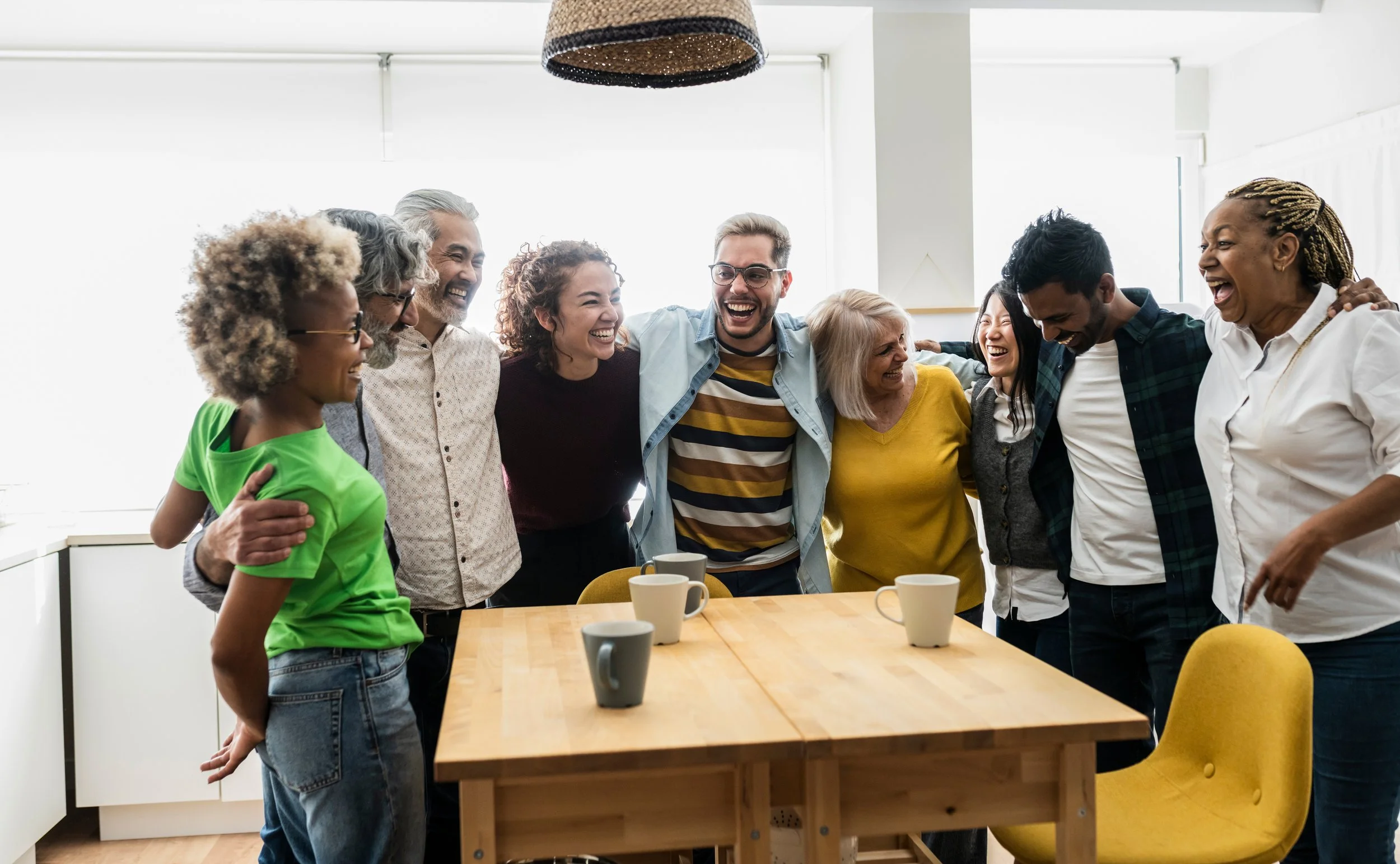 Diverse group of friends laughing together around a table
