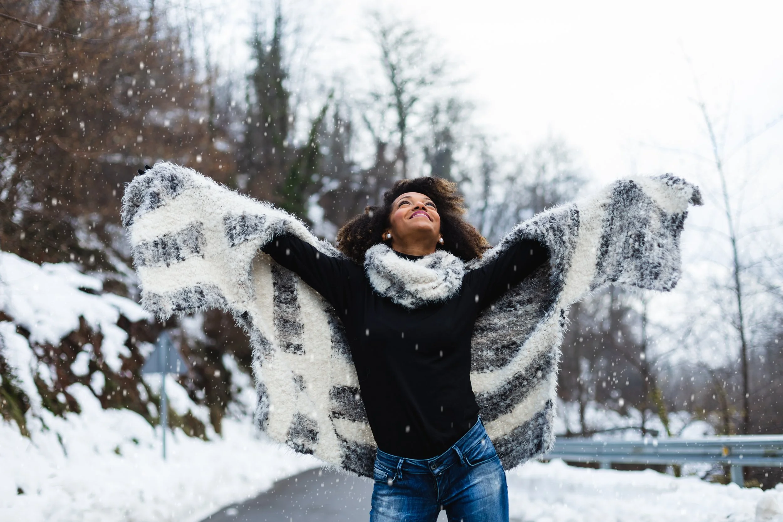 Woman with arms outstretched, enjoying a moment of joy in the snow