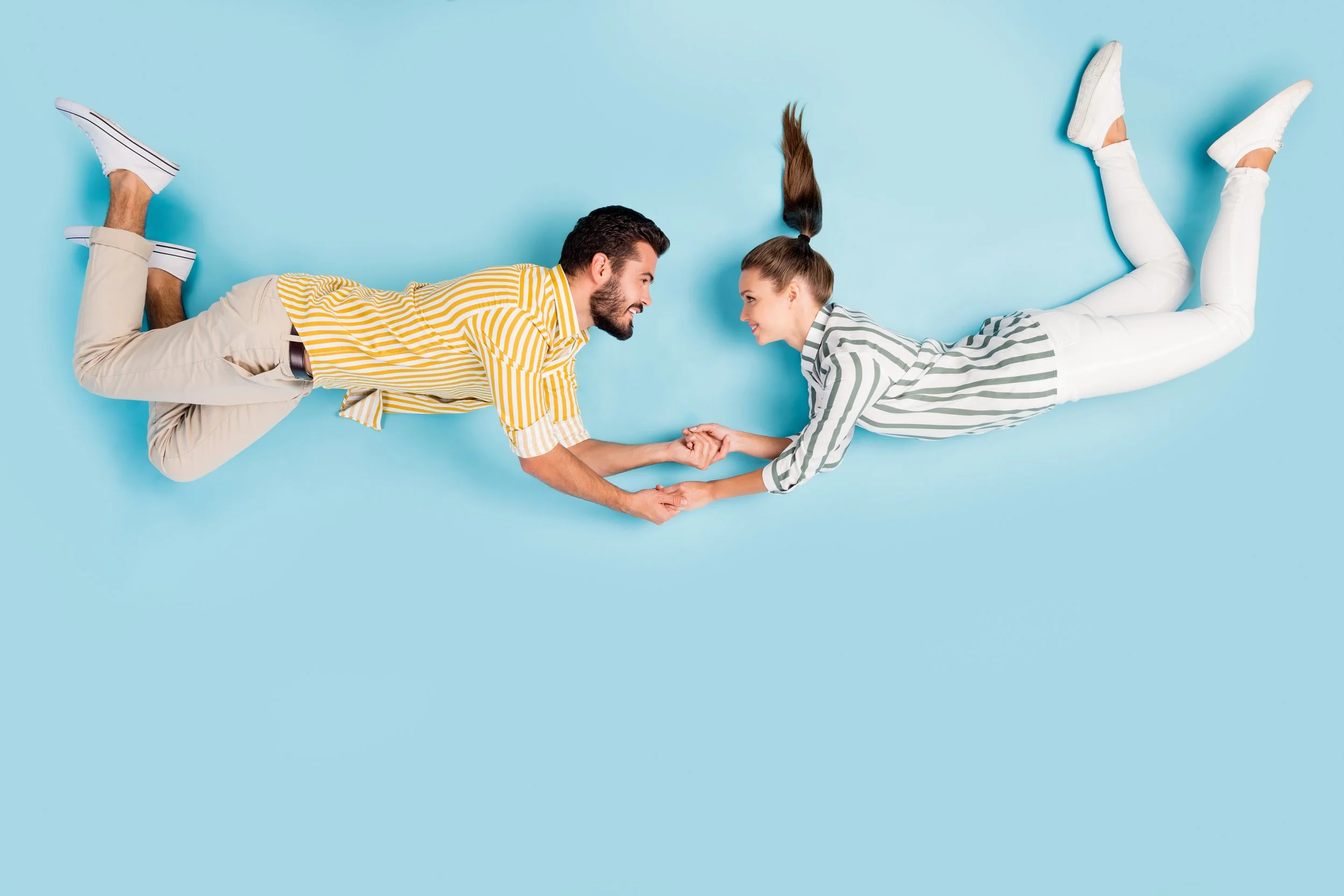 Playful couple holding hands and looking at each other