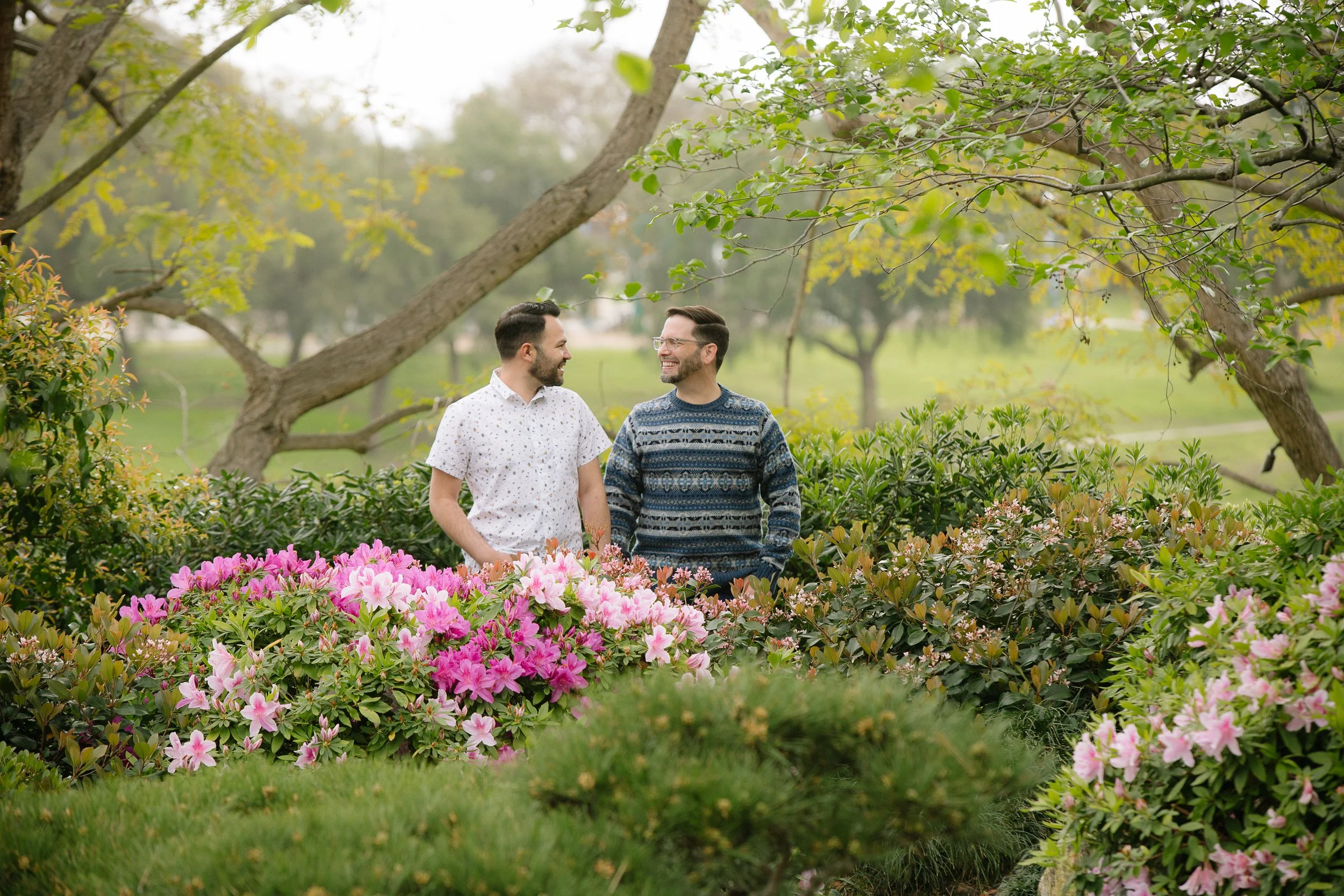 Dr. Greg Koch and husband, Jose, talking together in a flower garden