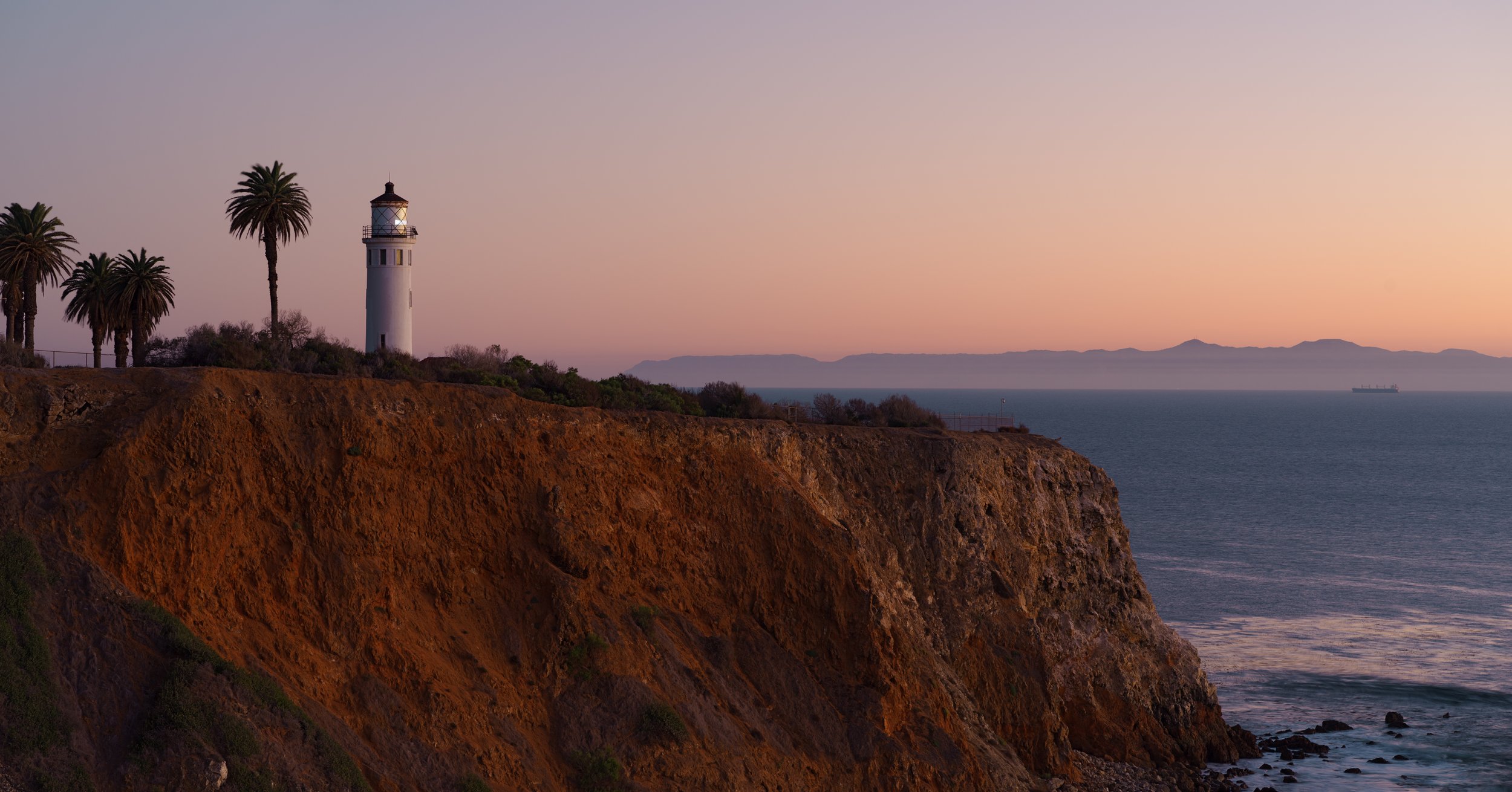 Coastal lighthouse standing watch over the ocean at dusk