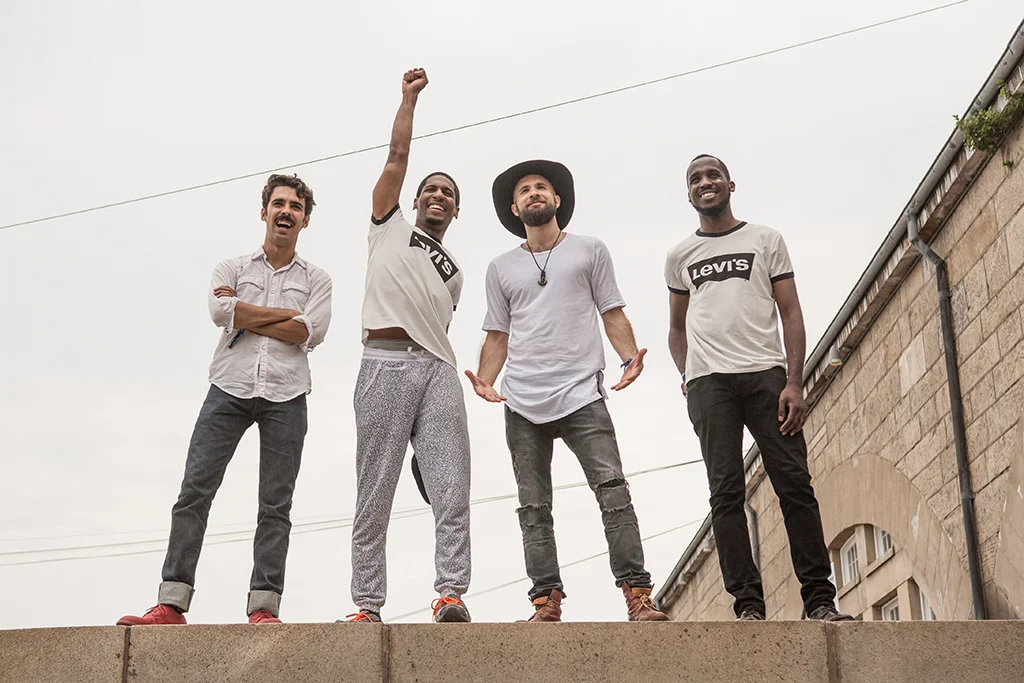 Jon Batiste & Stay Human pose for a photo on top of a wall inside Fort Adam. From left, are: Eddie Barbash, Jon Batiste, Joe Saylor and Ibanda Ruhumbika.