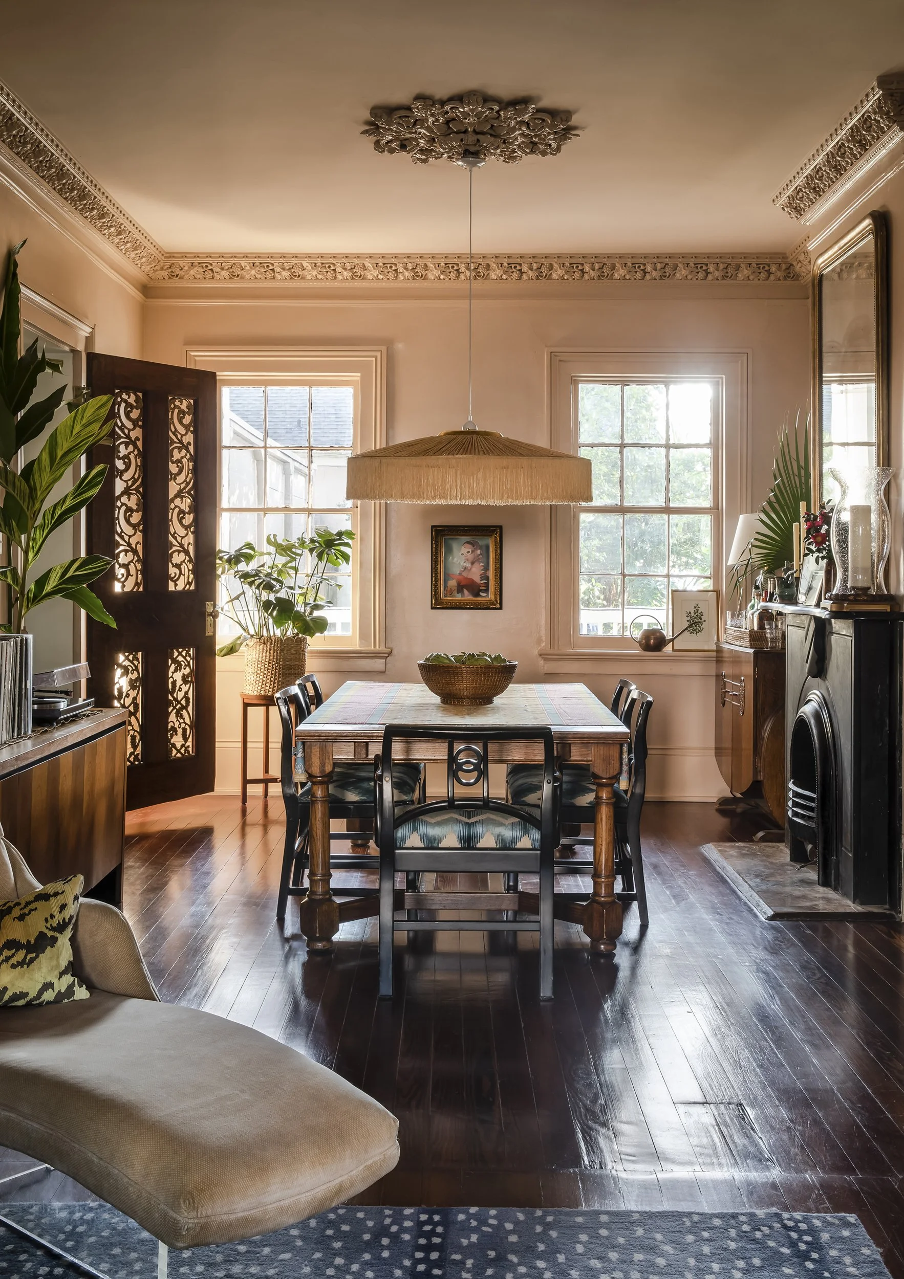 Moody New Orleans dining room in historic Greek Revival home with ornate plaster crown molding and ceiling medallions. 