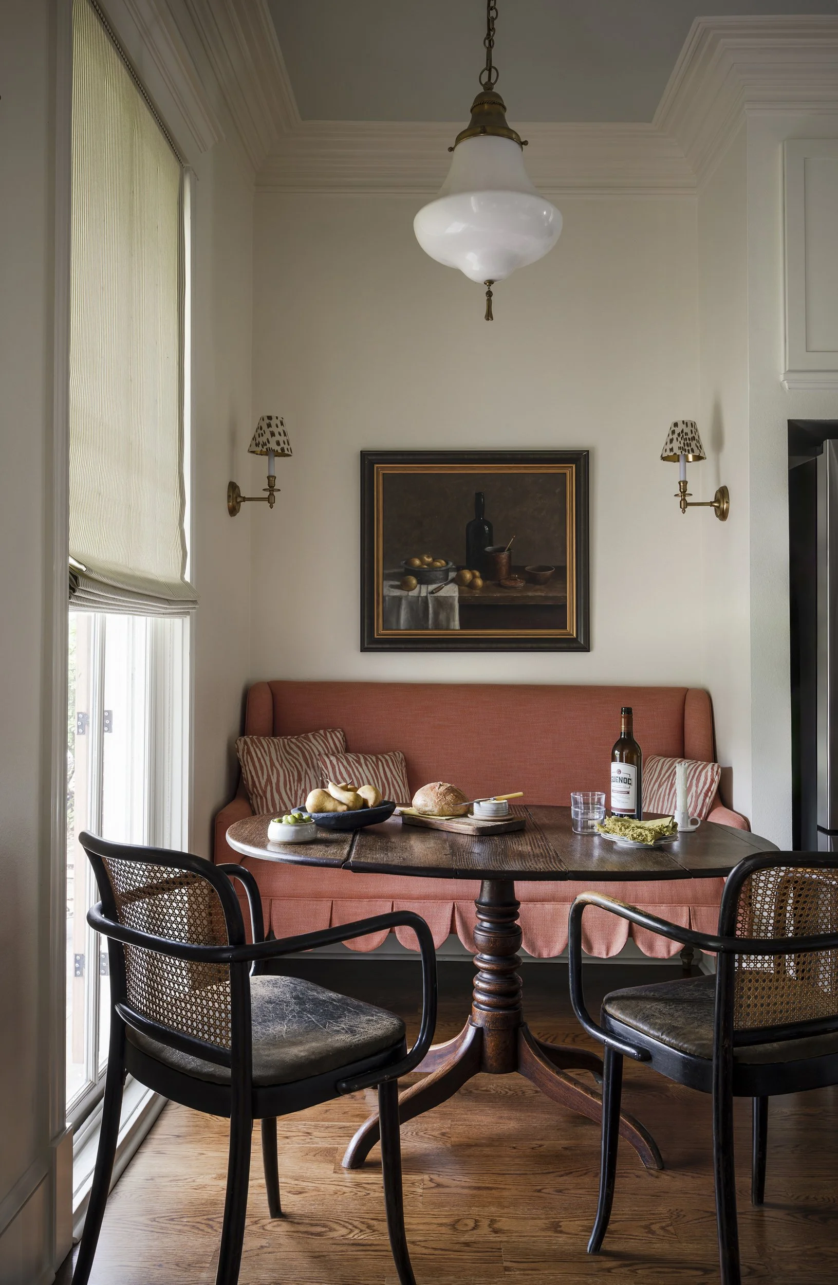 A charming dining nook with custom coral colored settee in New Orleans home. 