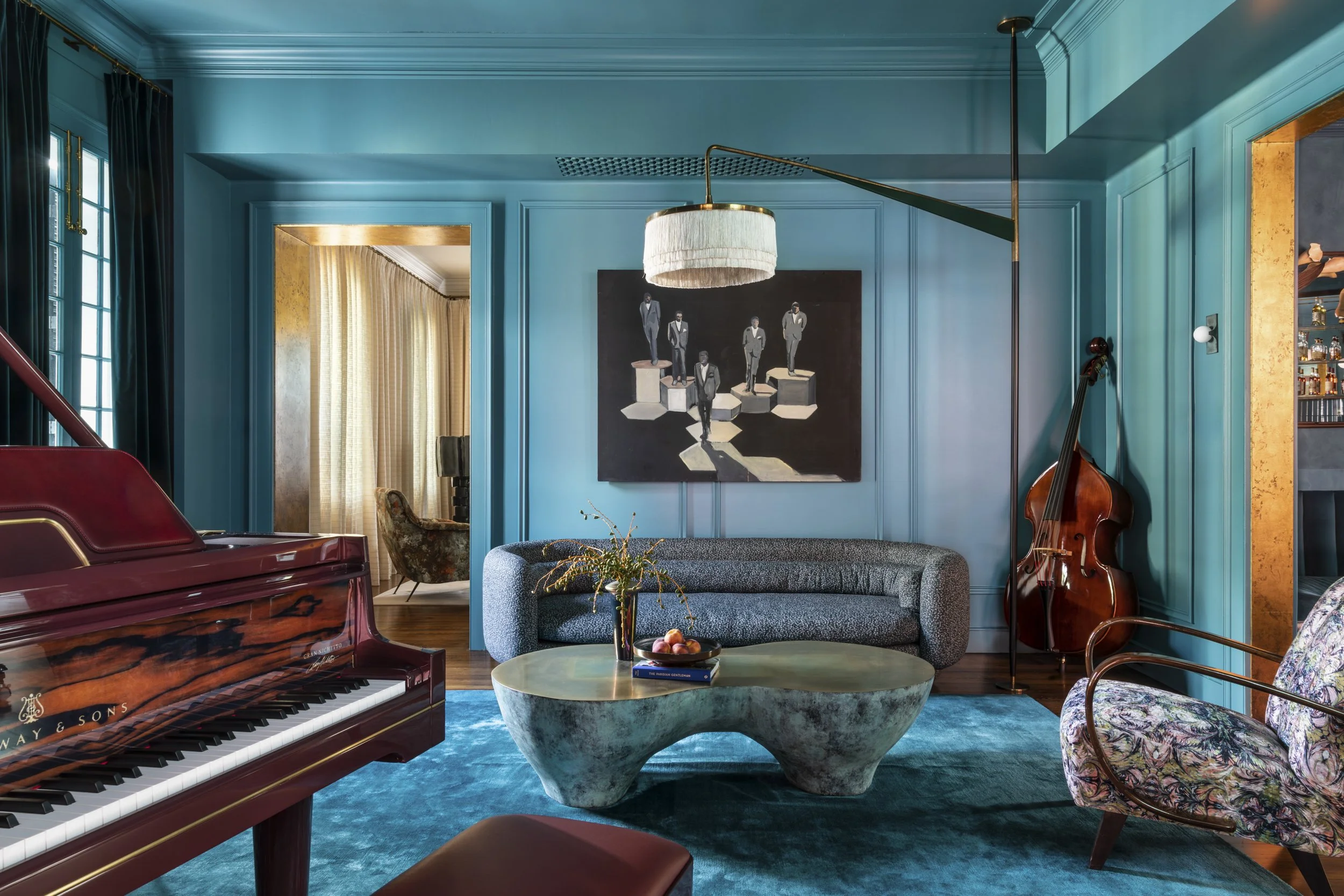 A music room painted in a vibrant shade of blue with a Steinway & Sons piano in a historic French Quarter Creole Cottage. 