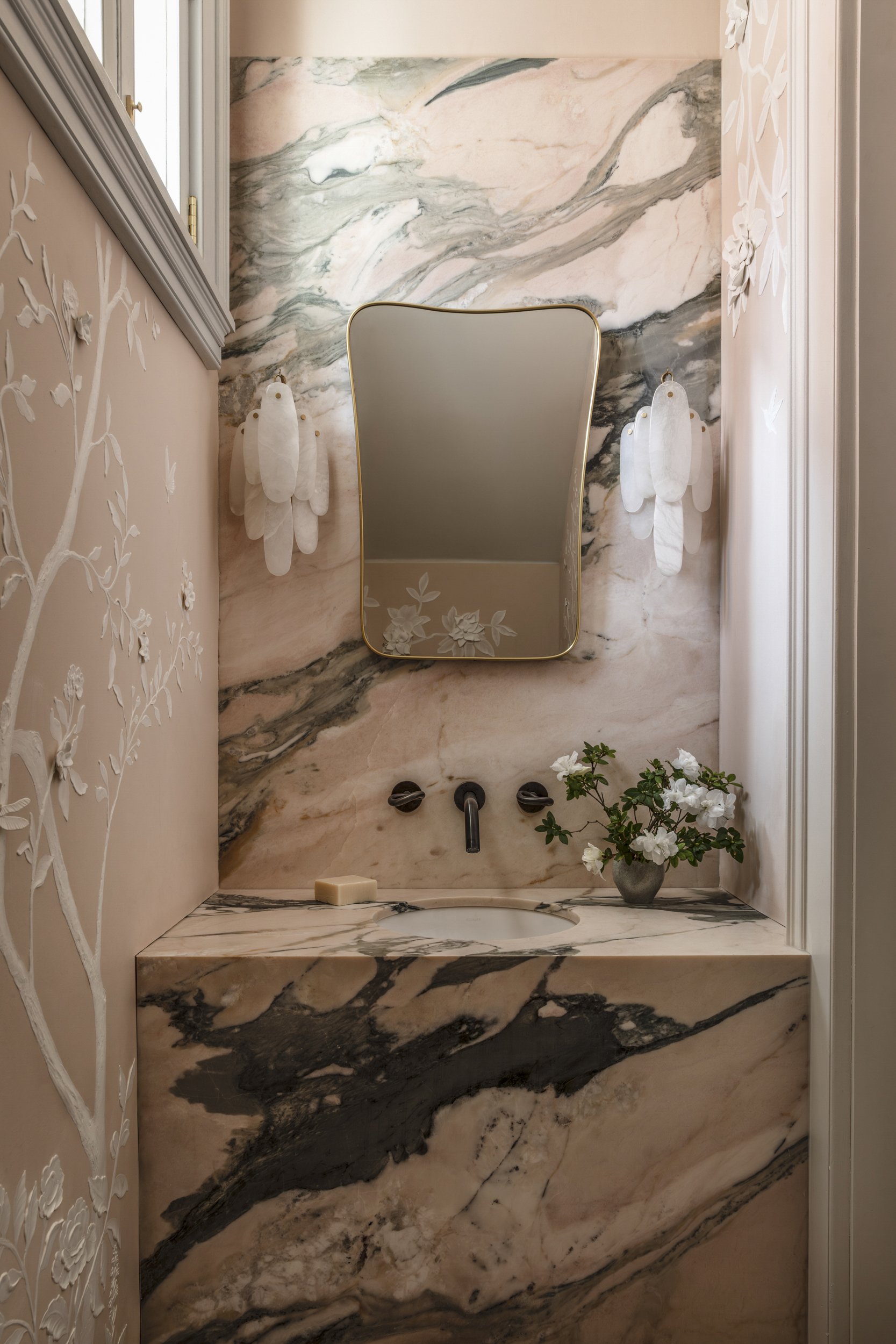 In the French Quarter cottage’s powder room, a bespoke vanity of arabescato rosso marble. Design by Young Projects; featured in Architectural Digest.