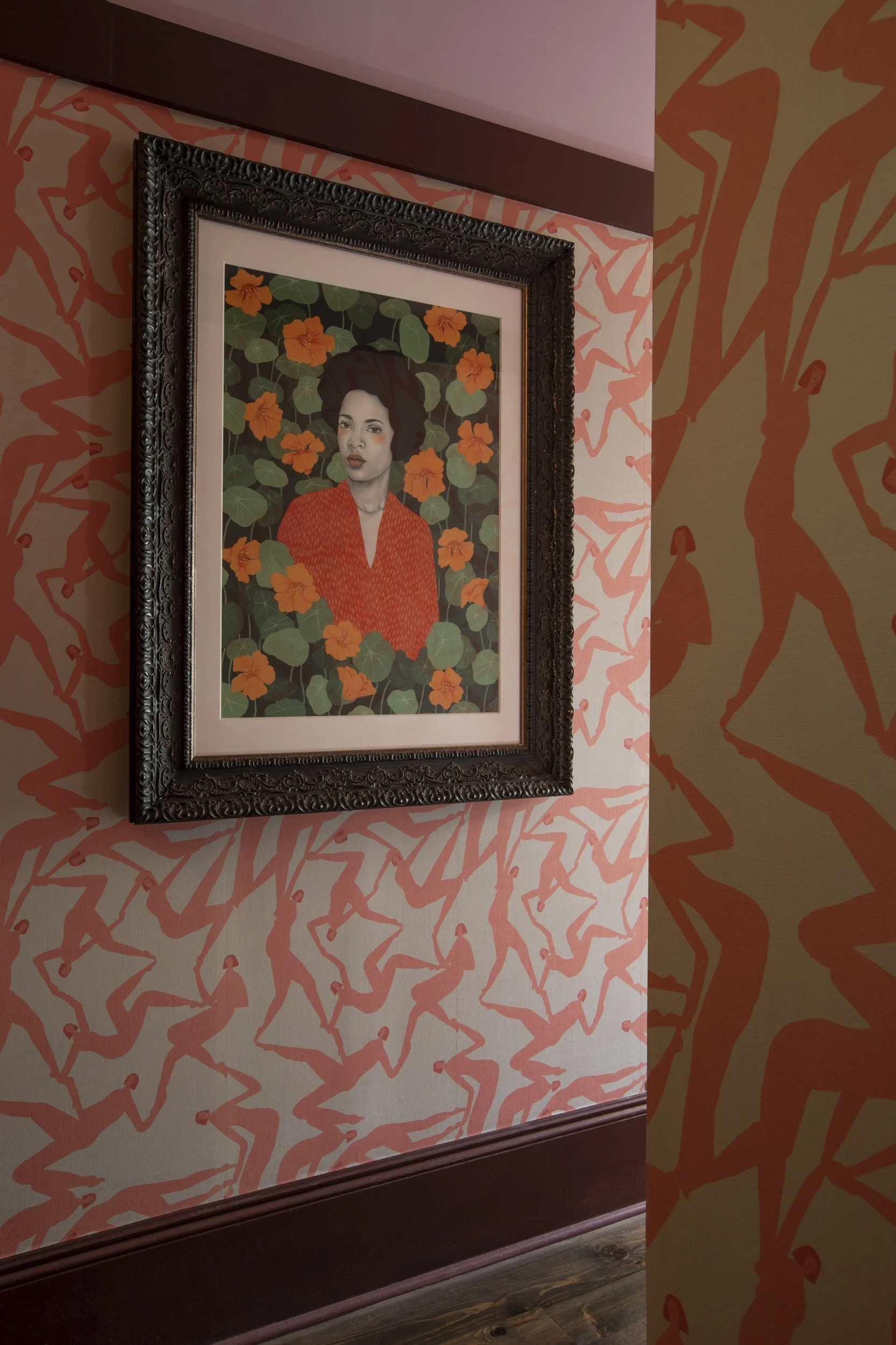 Coral patterned wallpaper with a gilt-framed portrait at the Frenchmen