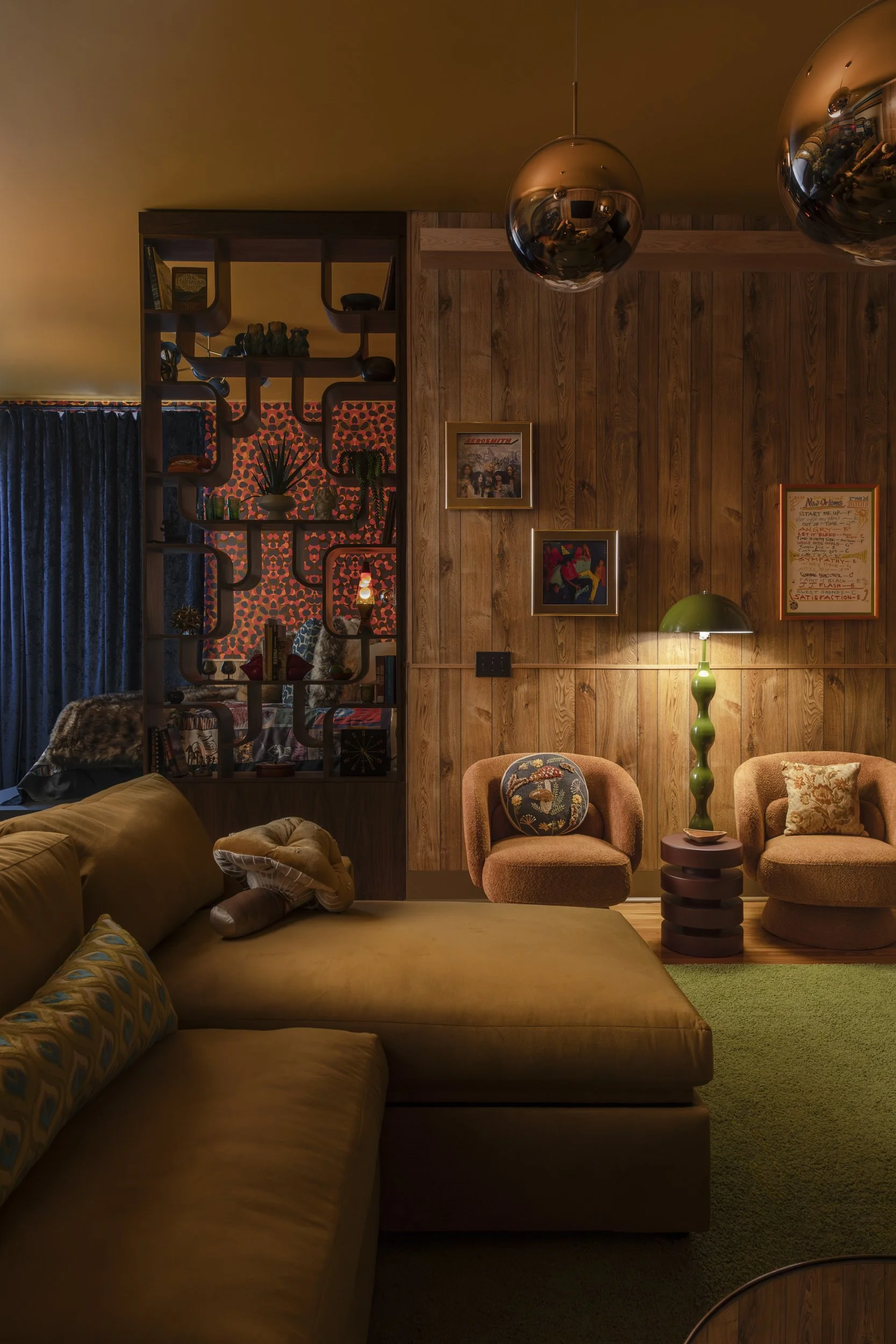 Wood-paneled lounge with mustard sectional and copper globe pendants in the Vinyl Room at Copper Vine