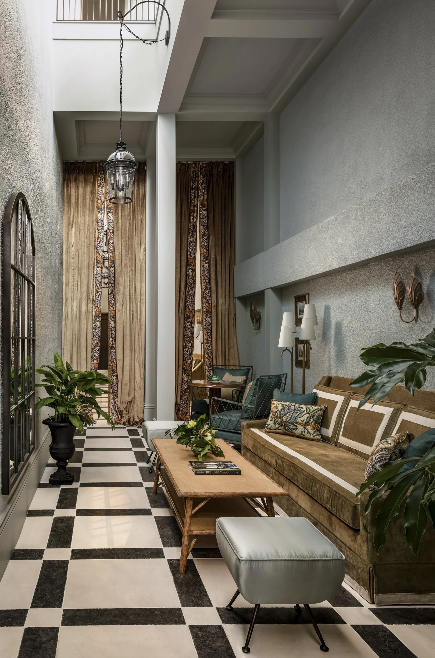 Long lounge corridor with drapery, seating and checkerboard marble floor at the Perle