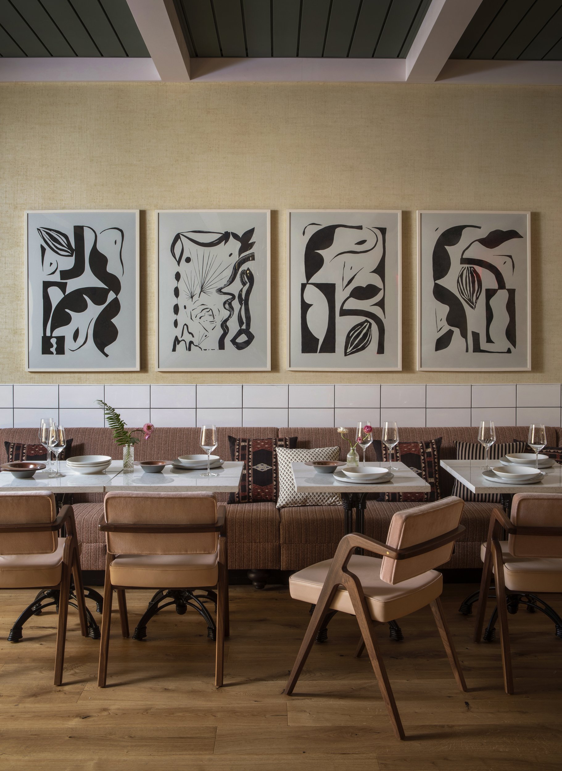 Four black-and-white works above a woven banquette in the restaurant at Virgin Hotels
New Orleans