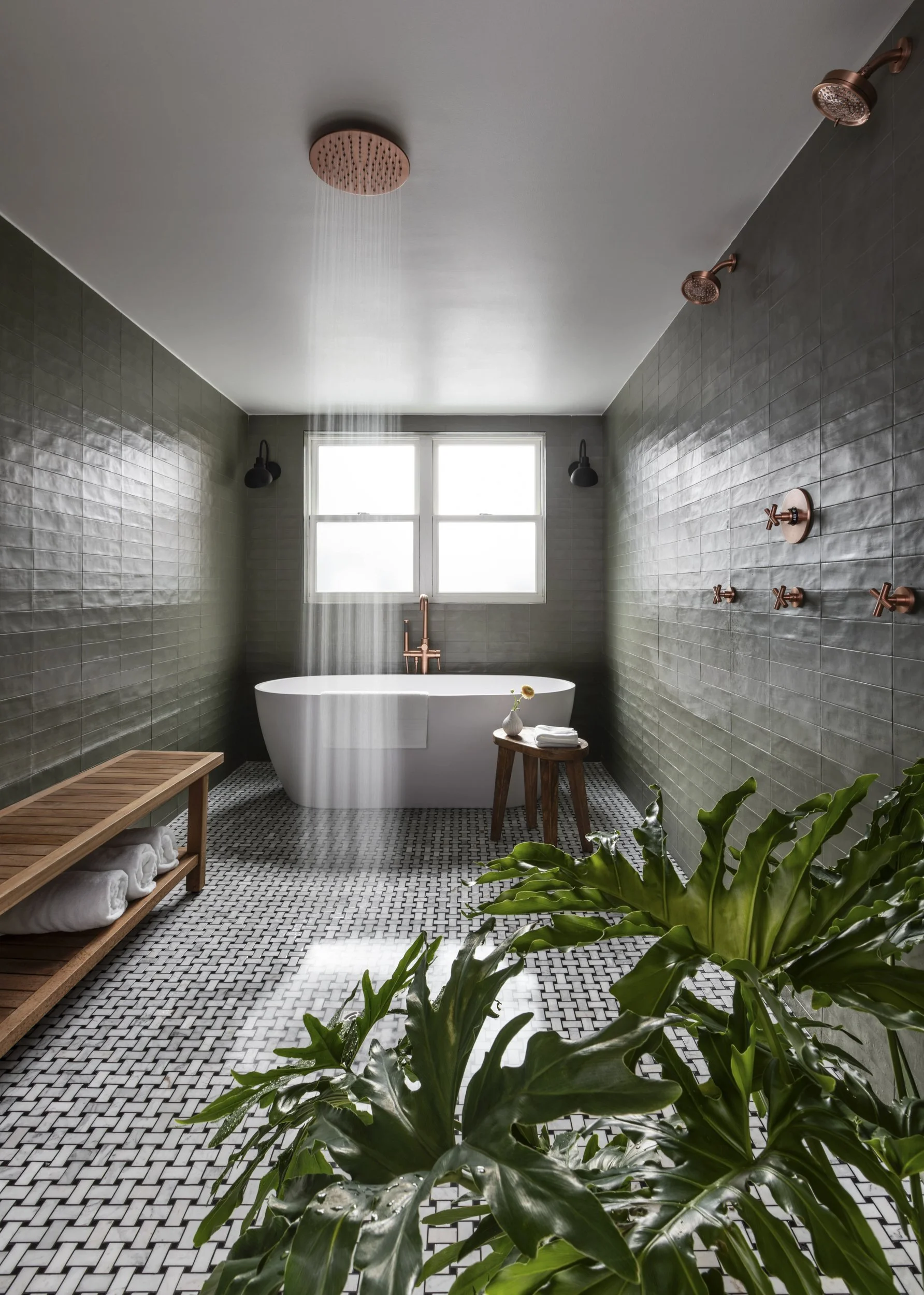 Bathroom with freestanding tub, dark green tile and patterned floor at Copper Vine