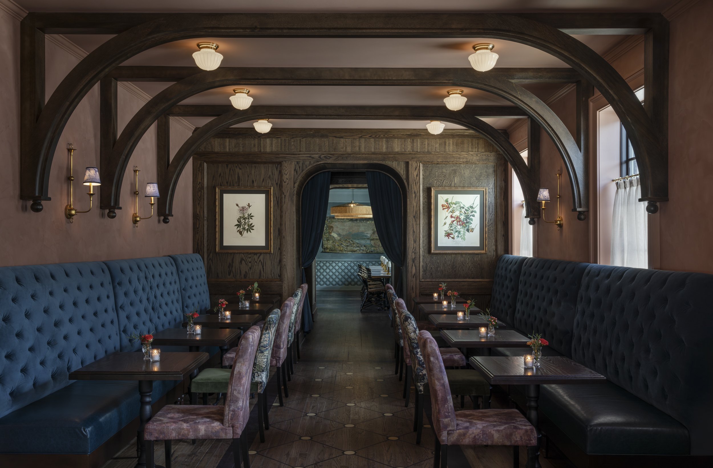 Arched oak beams above tufted banquettes and botanical prints at The Colonel’s Club,
Baton Rouge