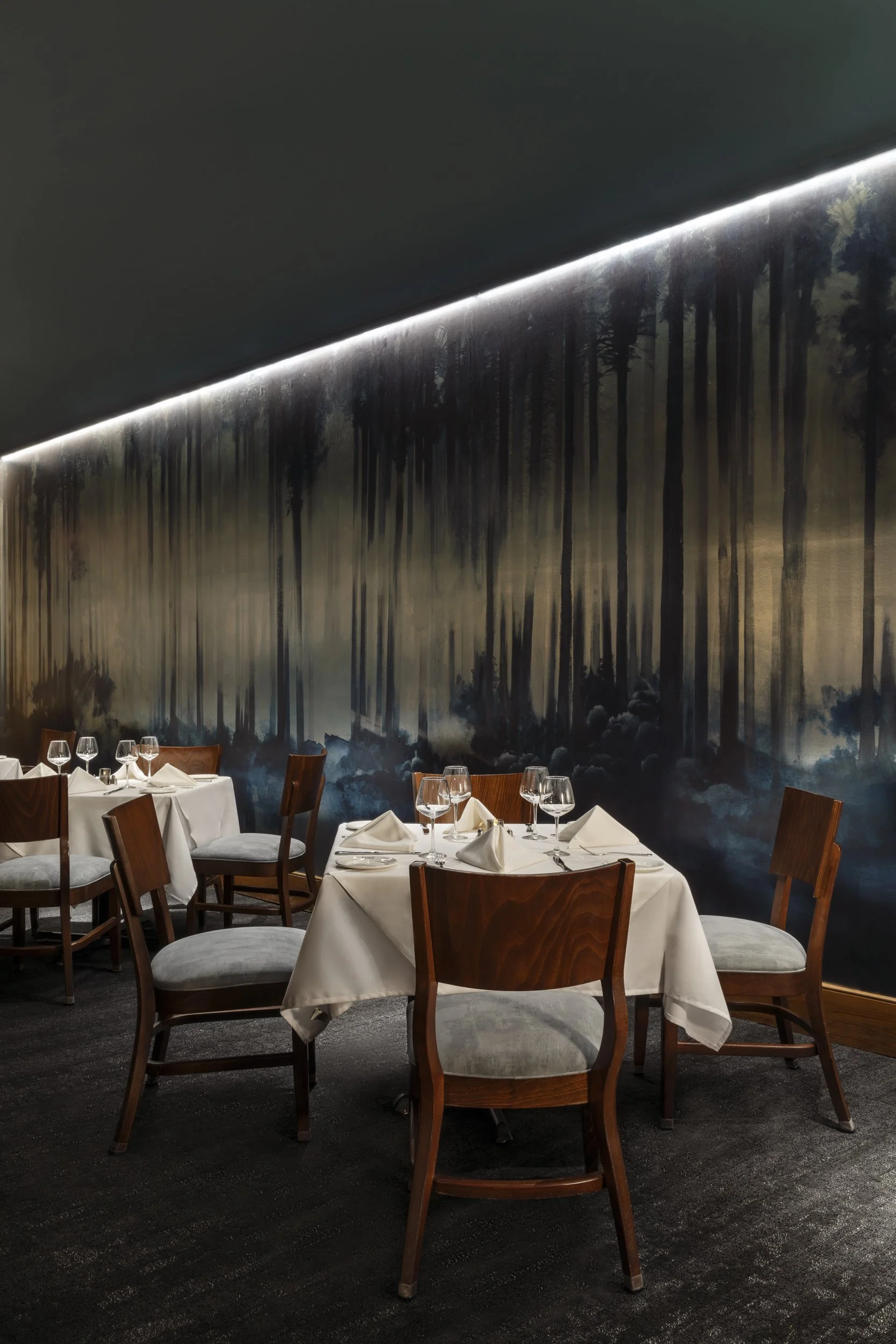 Painted forest mural above white-clothed tables at GW Fins in the French Quarter, New
Orleans