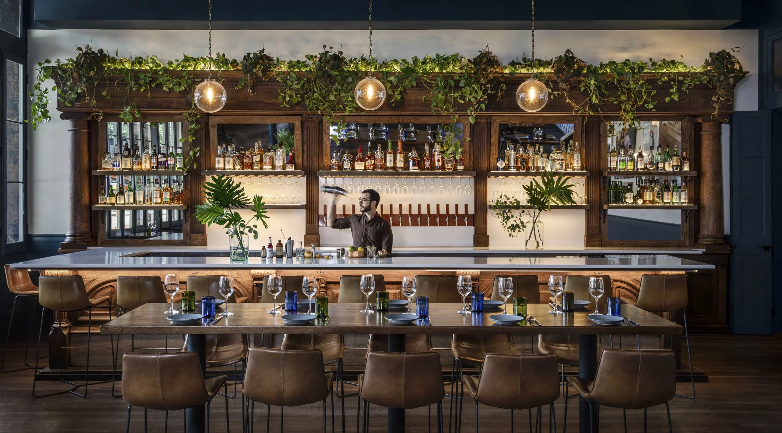 Bartender at work beneath trailing plants along the marble bar at Copper Vine, New
Orleans