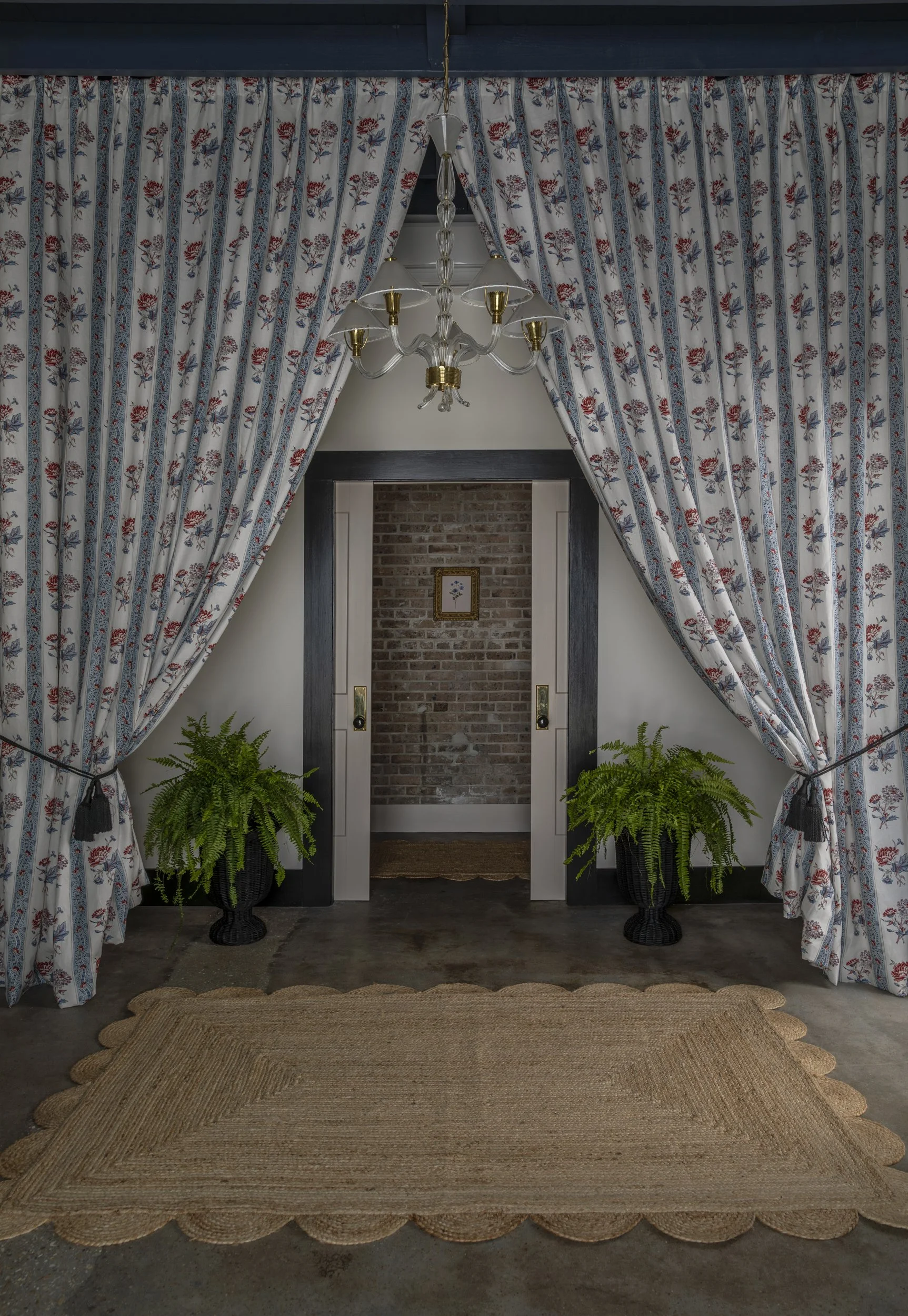 Doorway framed by patterned curtains with potted ferns on a jute rug at the Patterson