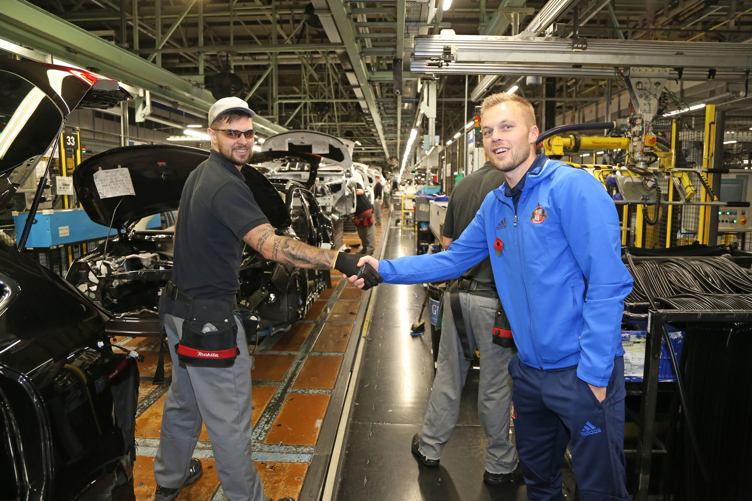 Få dage efter den britiske regering lavede en aftale med Nissan-ledelsen, var spillerne fra Sunderland på besøg på fabrikken, der er byens største arbejdsplads. Her hilser Sebastian Larsson på en af de ansatte. Foto: Getty Images