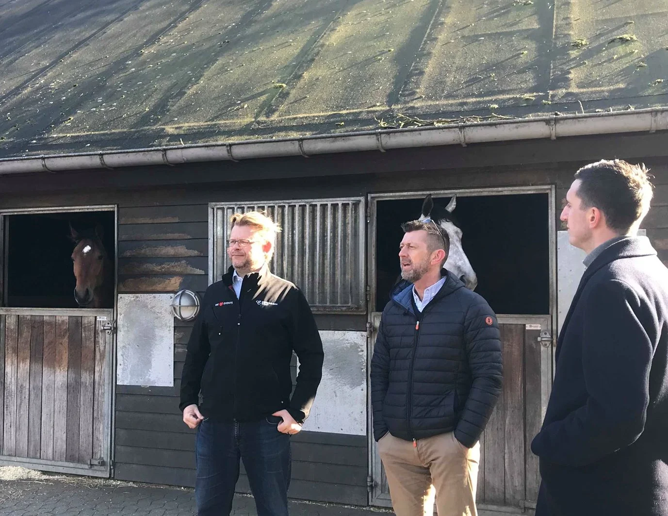 Direktør på Klampenborg Galopbane, Carsten Baagøe Schou (tv) viser Peter Brüchmann og Jonas Hebo Rasmussen rundt i staldene.