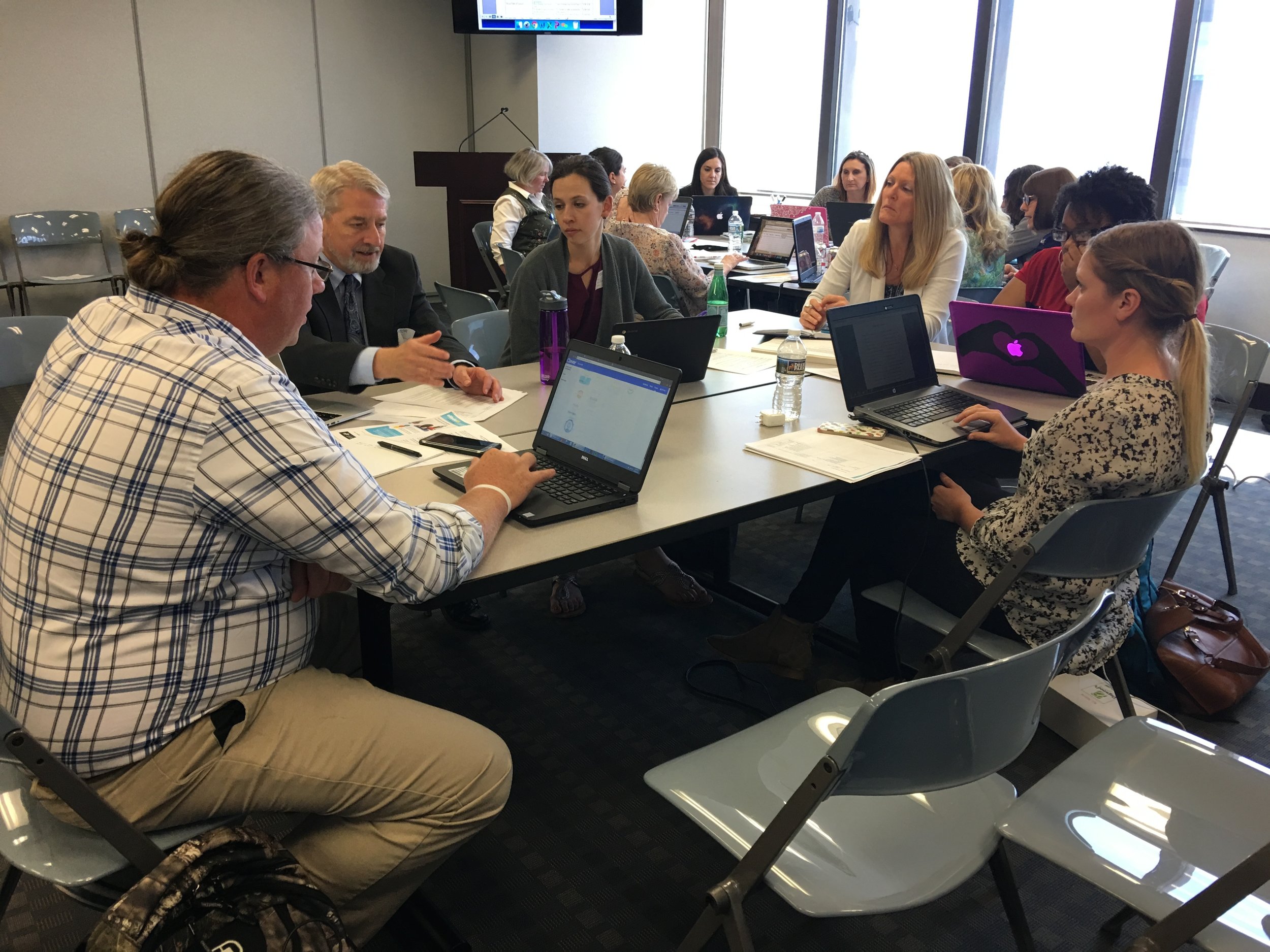 Teachers from various school districts work on an Algebra I OER textbook.