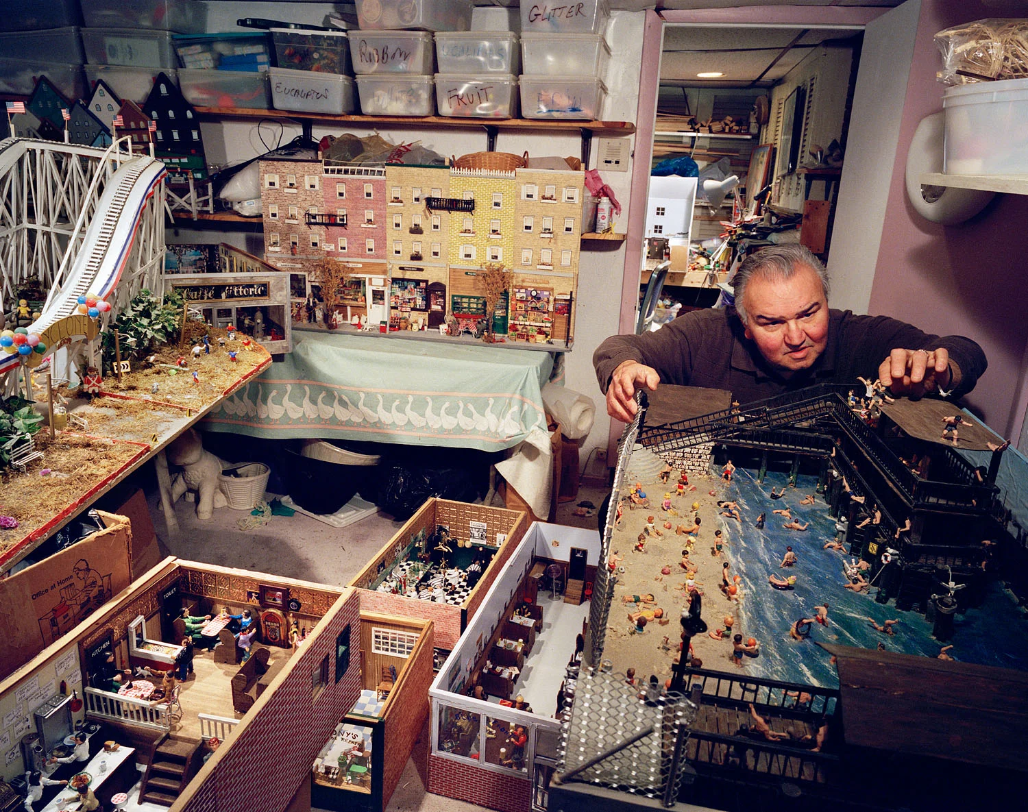 Man in his basement with models of North End businesses, including his barbershop, Boston, MA, 2003