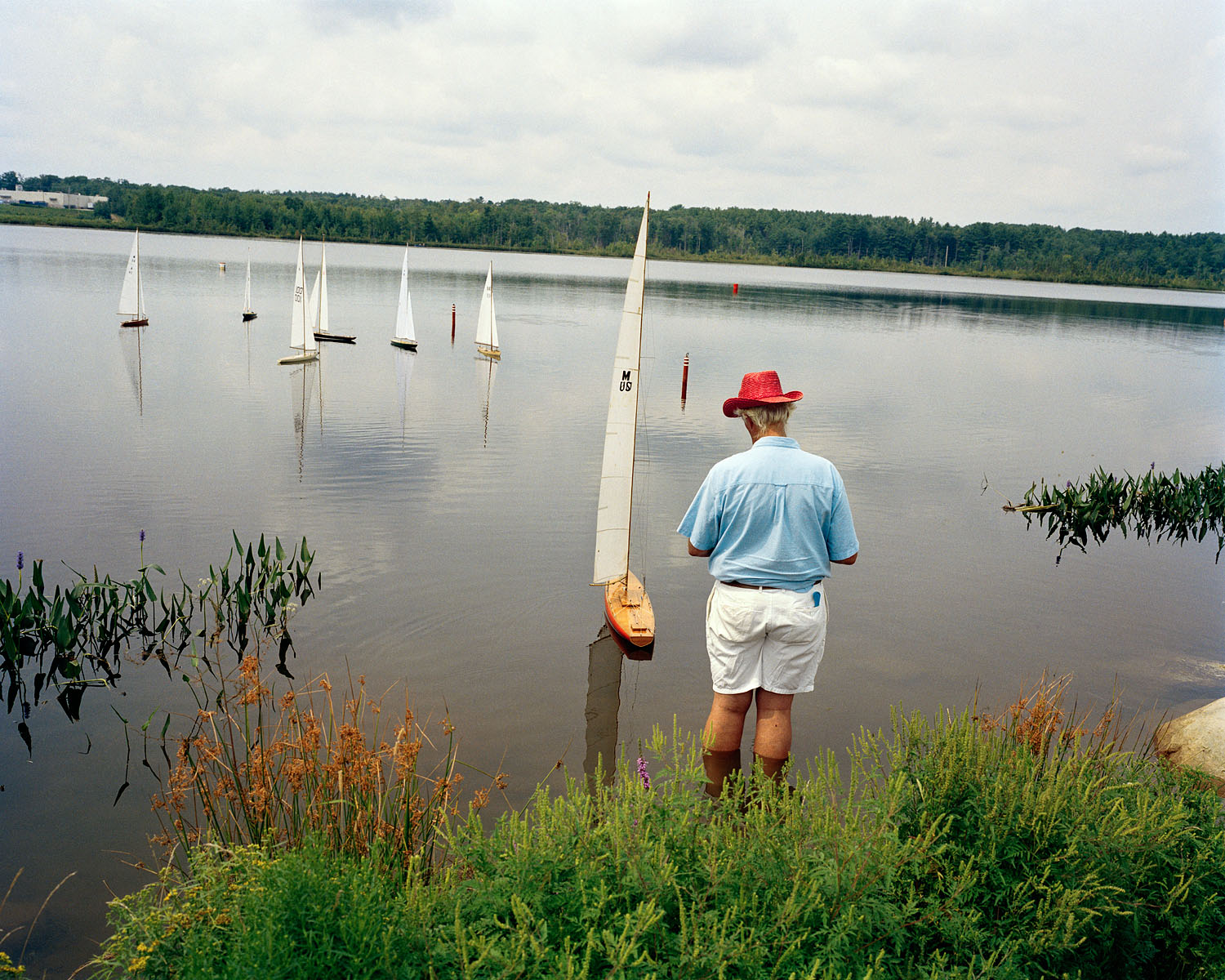 Man at radio-controlled sailboat regatta, Gilford, NH, 2003