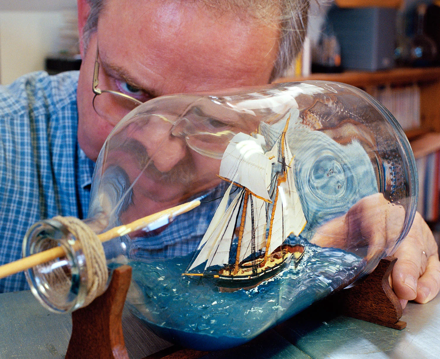 Man repairing ship-in-a-bottle, Newburyport, MA, 2002