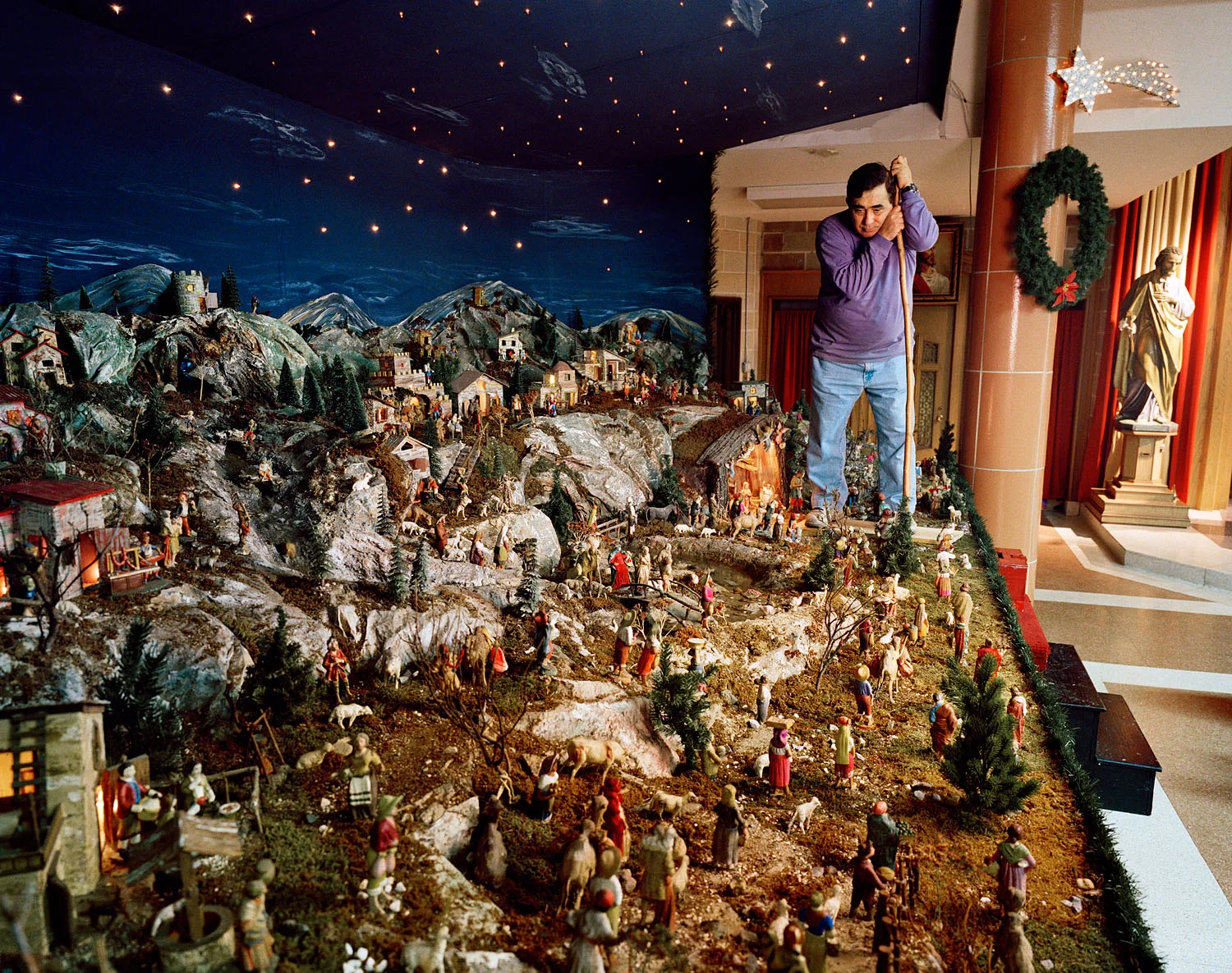 Man in church basement with Nativity scene, Brooklyn, NY, 2002