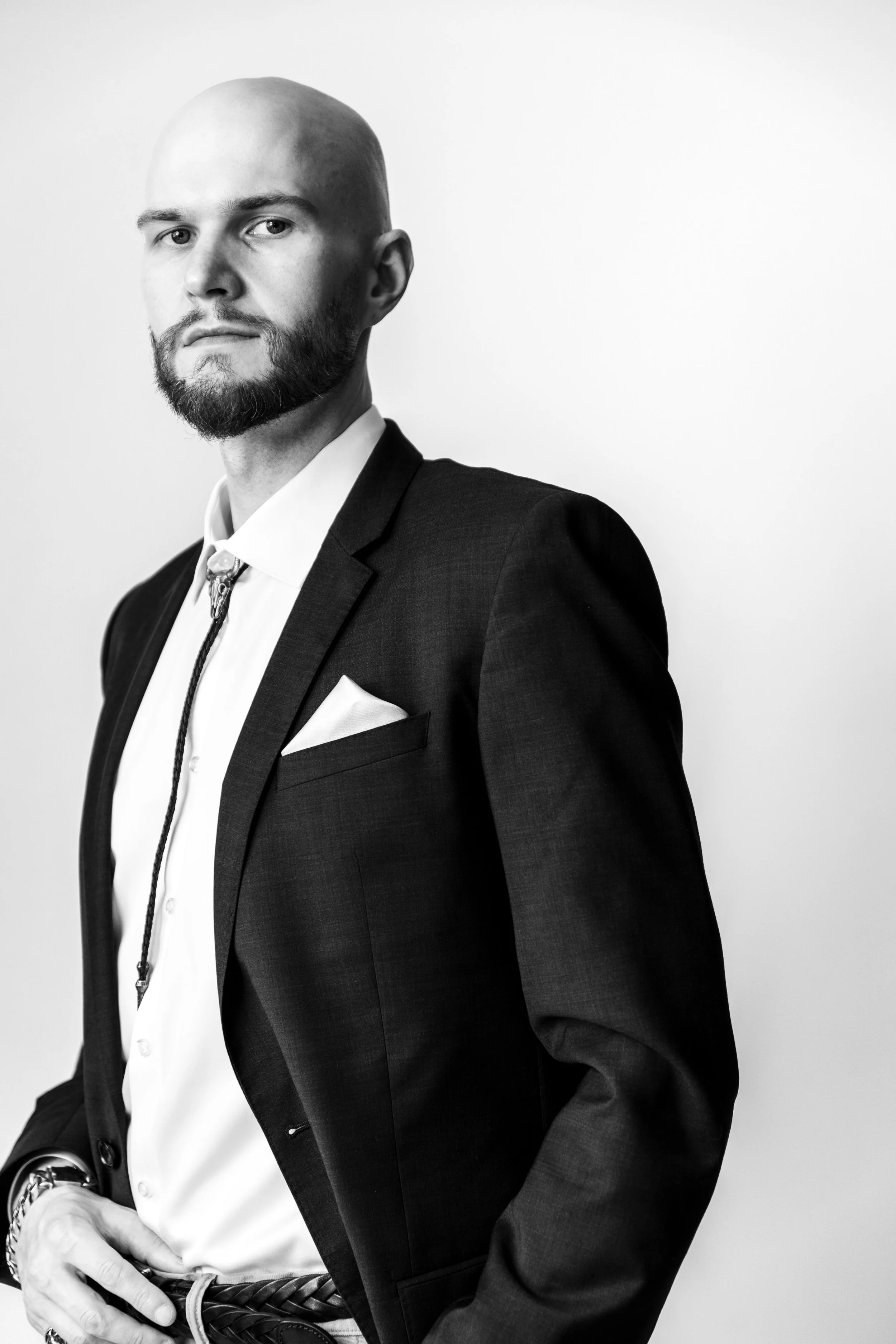 Graham K. Miles wearing suit and standing while looking into camera