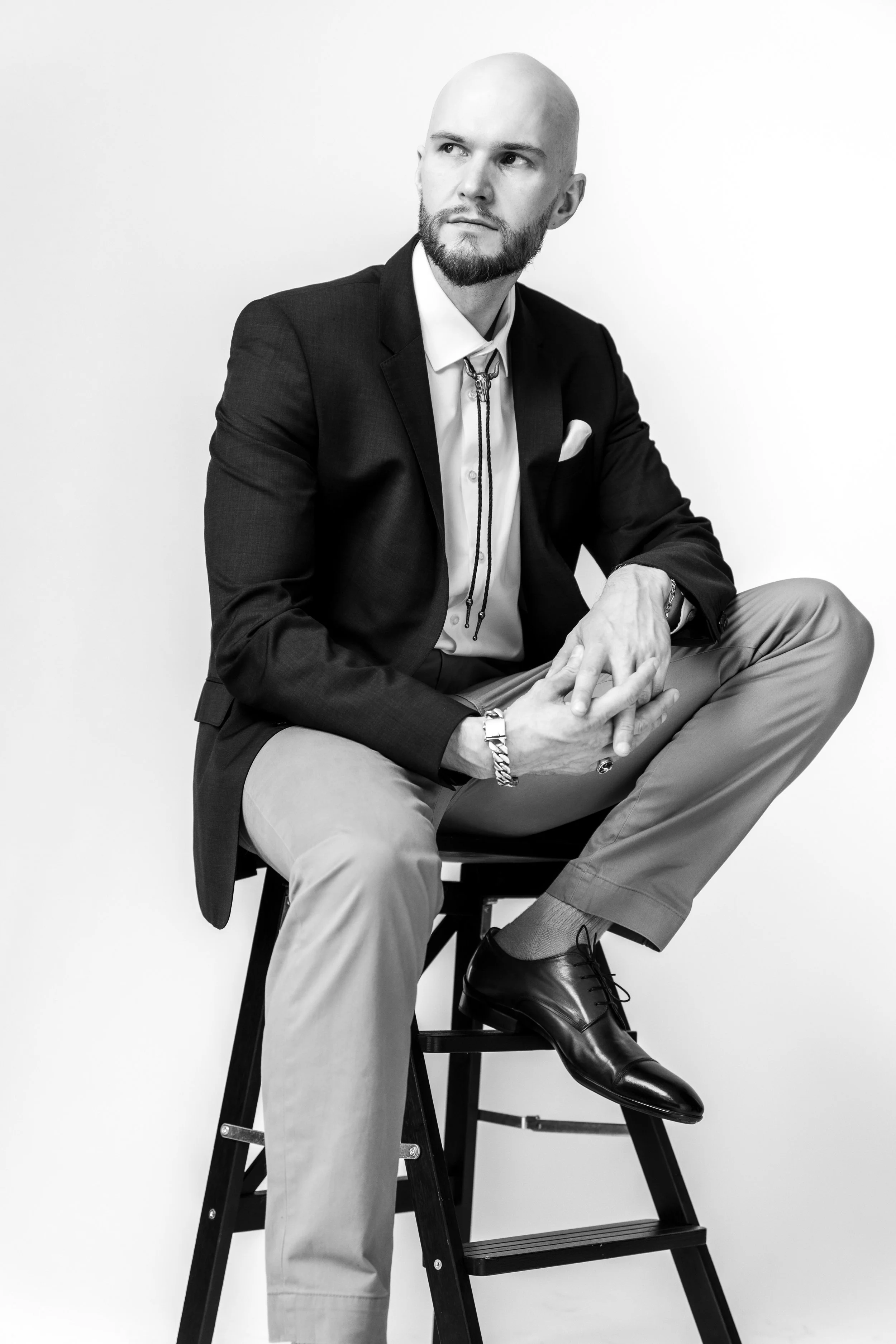 Graham K. Miles wearing suit and looking into distance while sitting