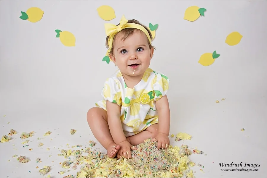 happy-one-year-old-girl-completed-cake-smash-with-destroyed-cake-at-Calgary-studio