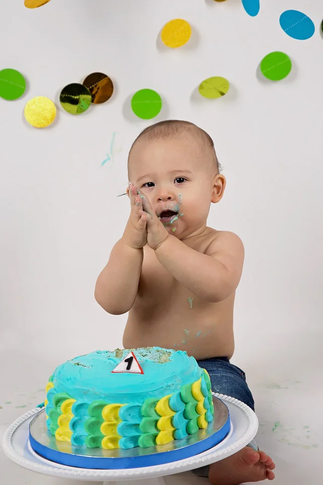 Baby-boy-at-construction-themed-Calgary-studio-cake-smash-with-blue-and-yellow-cake-and-dot-decorations
