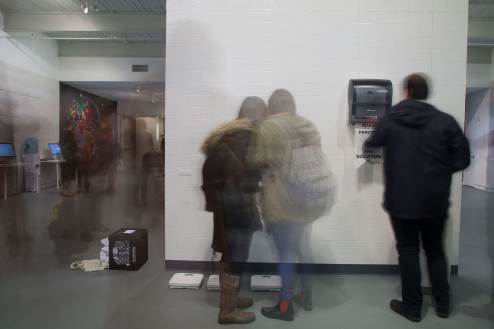  My thesis exhibition,  Wake Up , was a two sided wall that invited viewers to engage with a series of designed disruptions. Side one of the wall boasted white bathroom tile, a functioning paper towel dispenser, scales, and a vintage trash can.&nbsp;