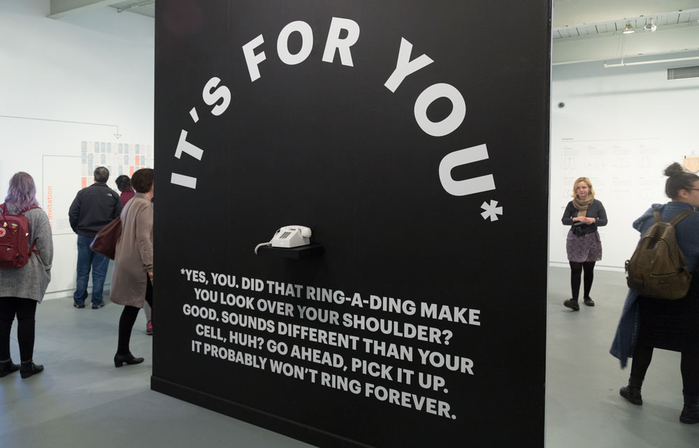  Side two of the instillation was a matte black wall with white vinyl. The visual language referred back to the paper towels on the opposite side, while acting as a strong counterpoint to the white tile. The phone sitting under the arched message was
