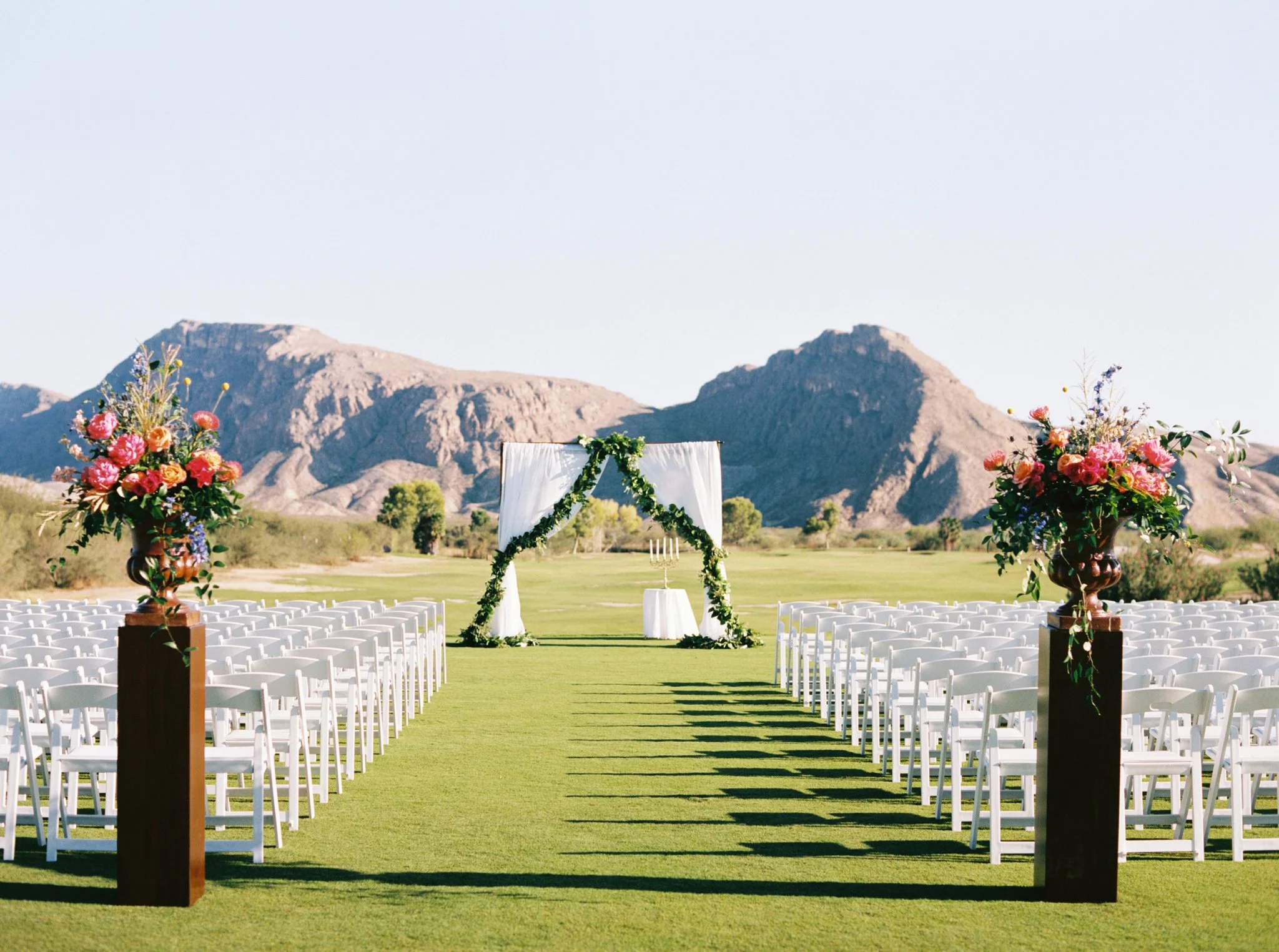 With the most stunning mountain backdrop, Lacie and Stewart used drapery and greenery to pull the audience into the ceremony. They also had the most stunning colorful bouquets leading people to the aisle. You can see more of this wedding here . Floral Design: Viridian Design Studio | Venue: Lajitas Resort 