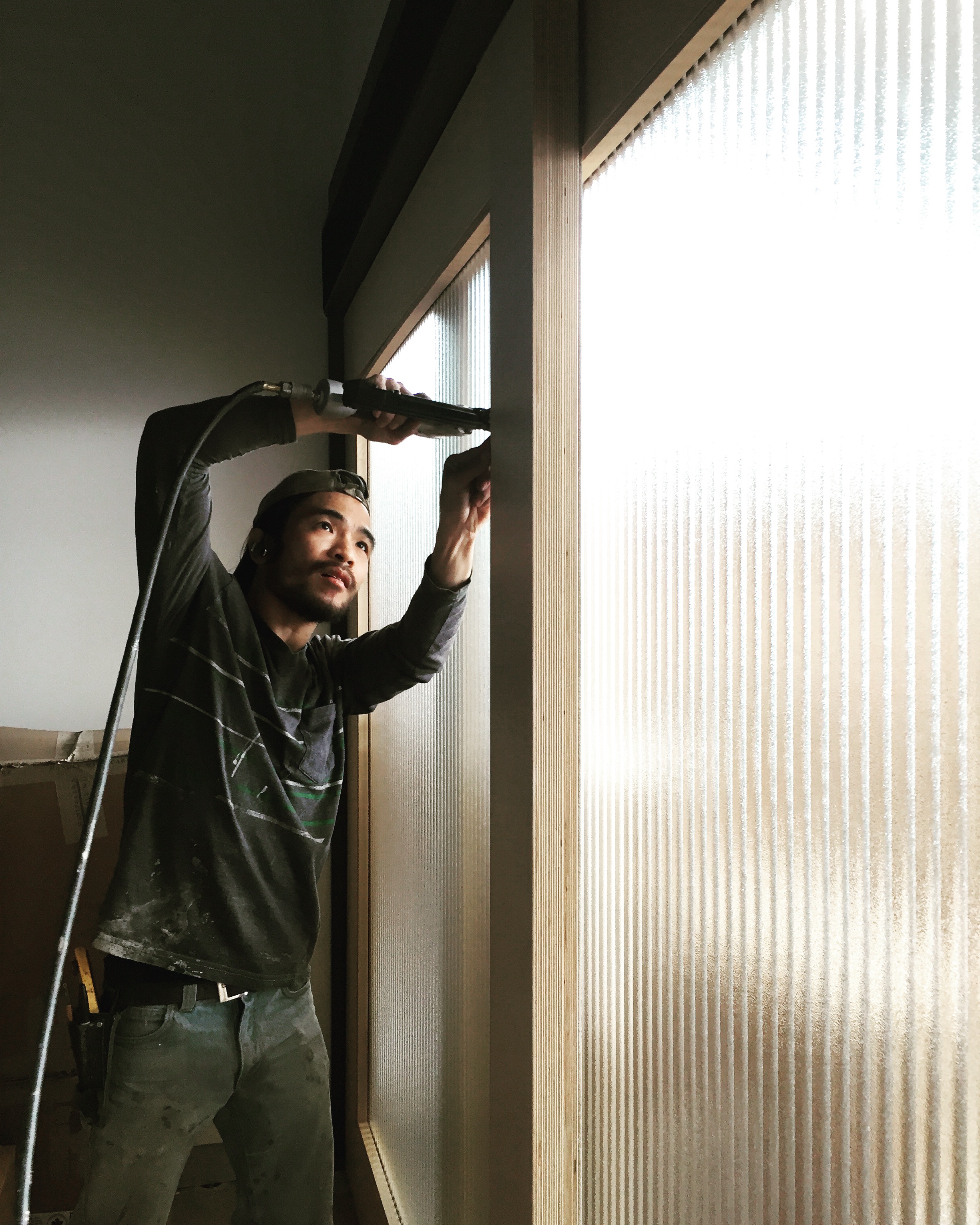 I took this picture of Rock while he worked on getting the doors installed months ago while NXL was under construction. Light through fluted glass is so beautiful. 