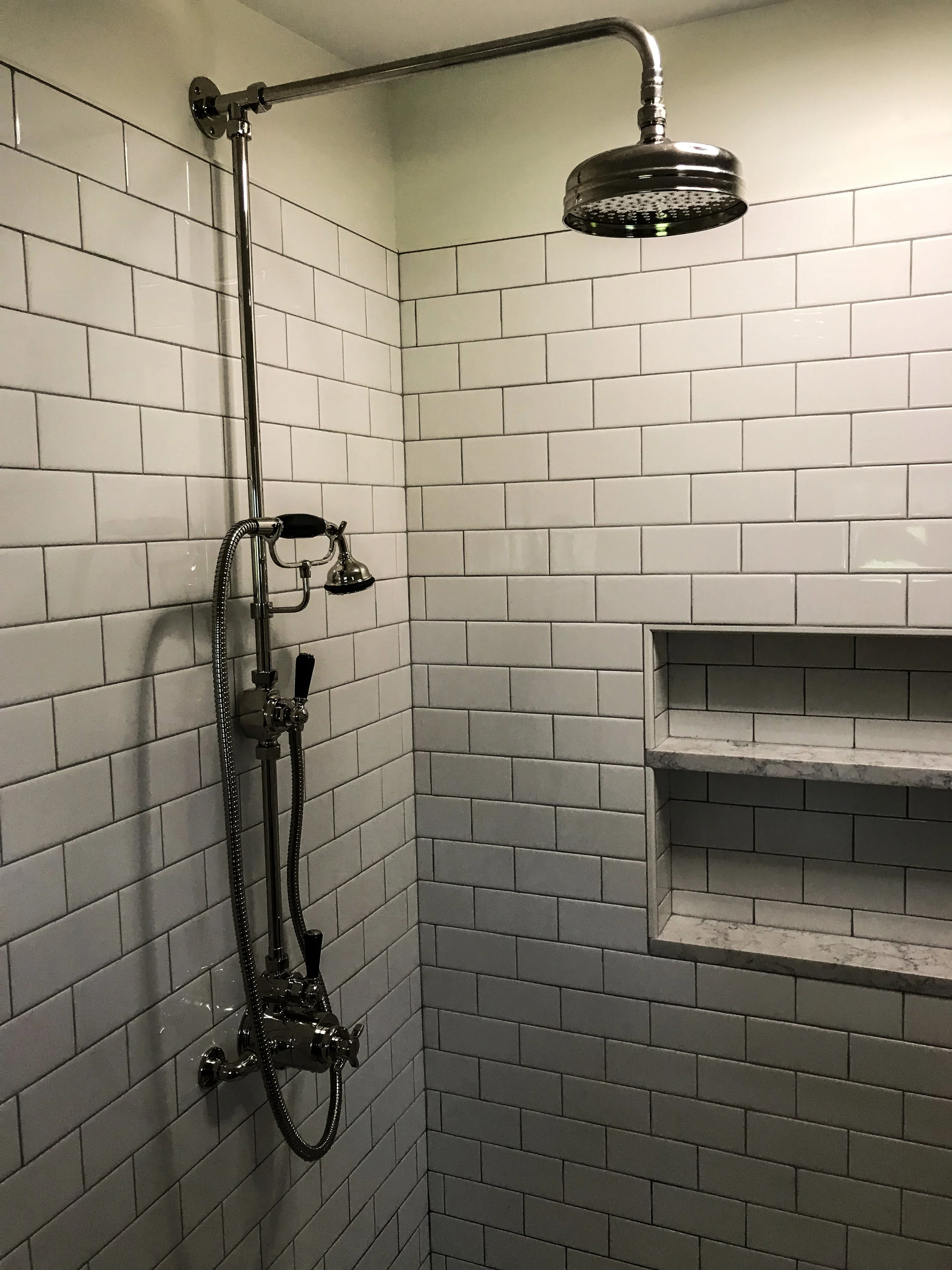 subway tile with exposed shower faucet.jpeg