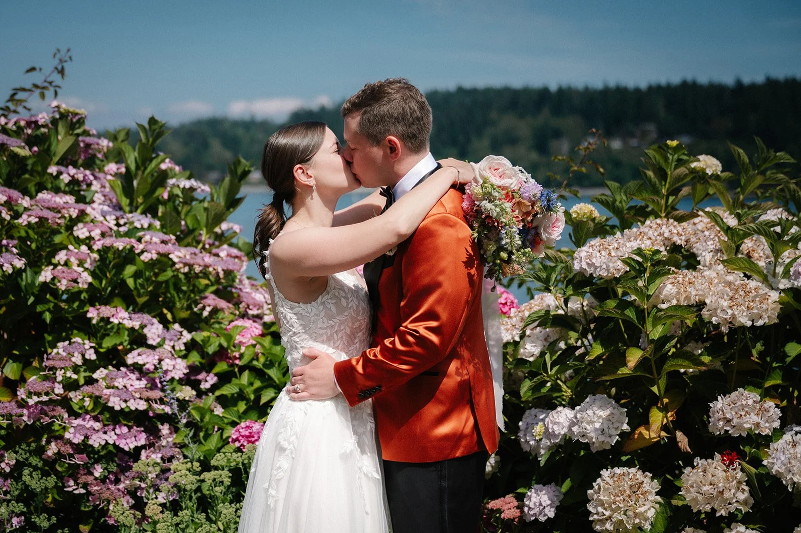 wedding couple kissing surrounded by flowers during their garden wedding day in seattle