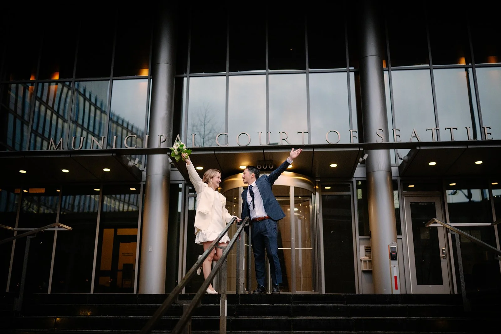 cheerful bride and groom in front of the seattle municipal courthouse