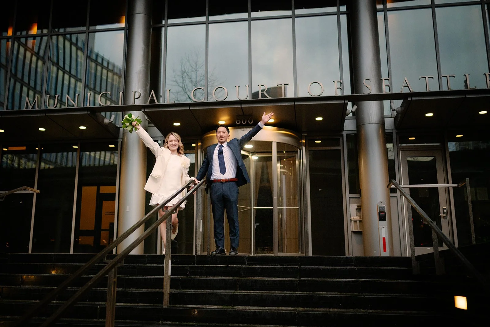 cheerful bride and groom in front of the seattle municipal courthouse