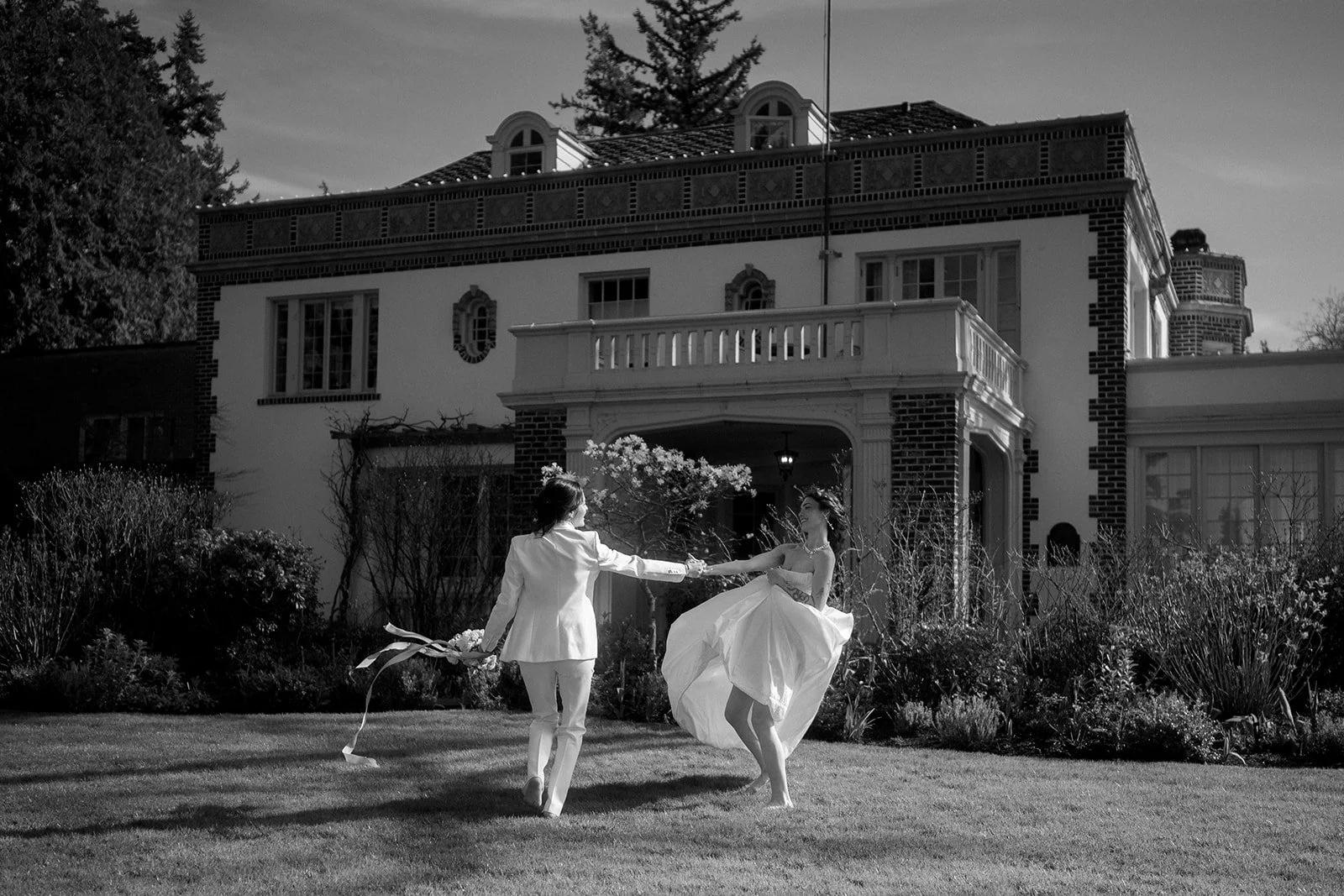 queer wedding couple running around the lush grounds during their lairmont manor wedding