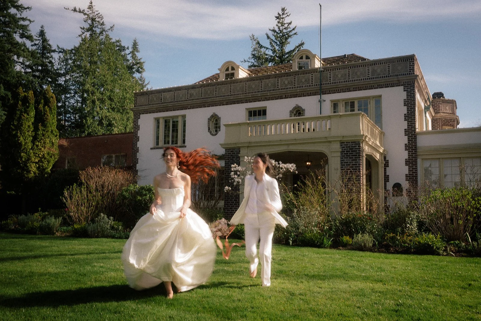 queer wedding couple running around the lush grounds during their lairmont manor wedding