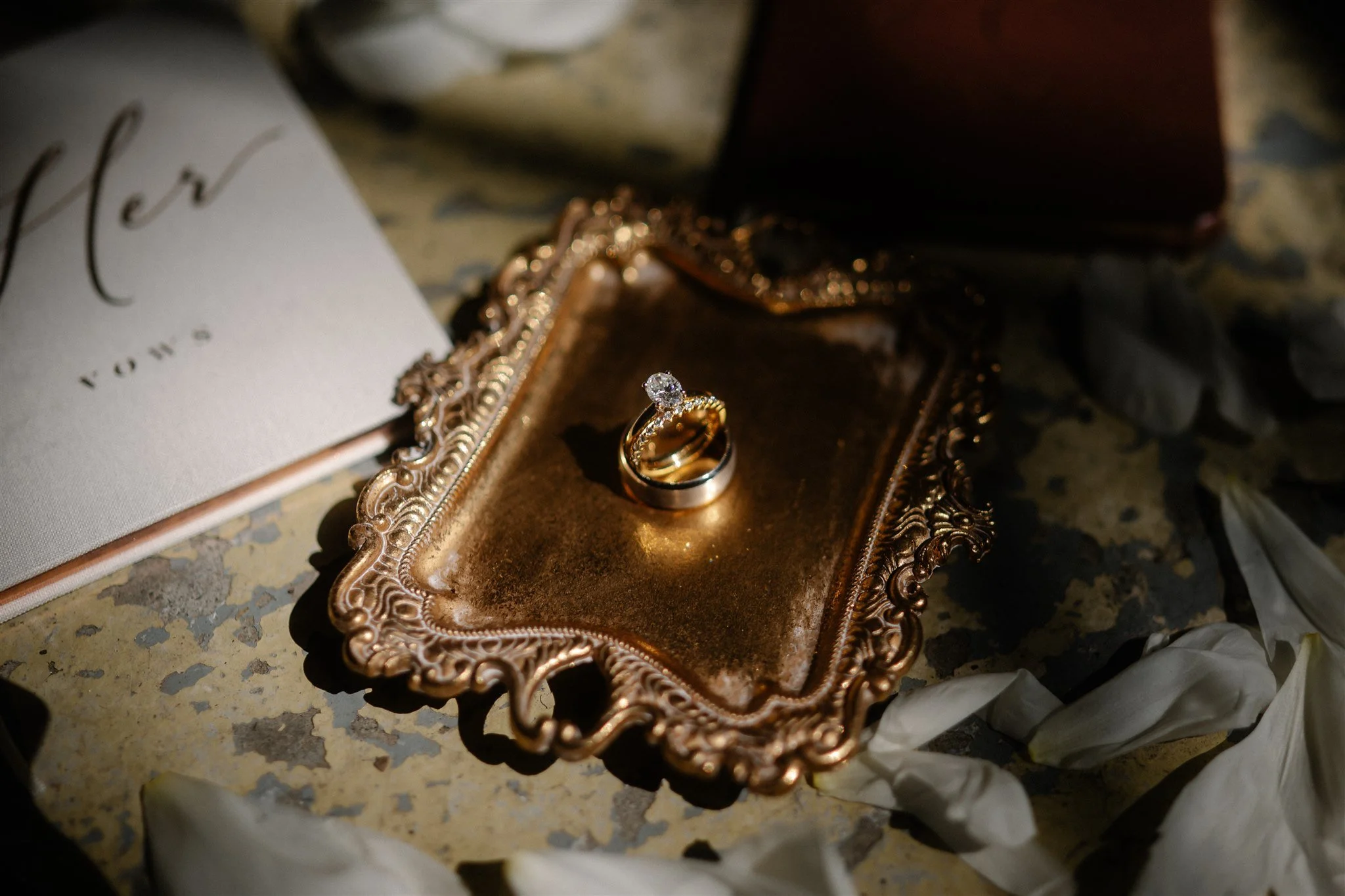 Moody wedding flat lay photography with petals and wedding stationery