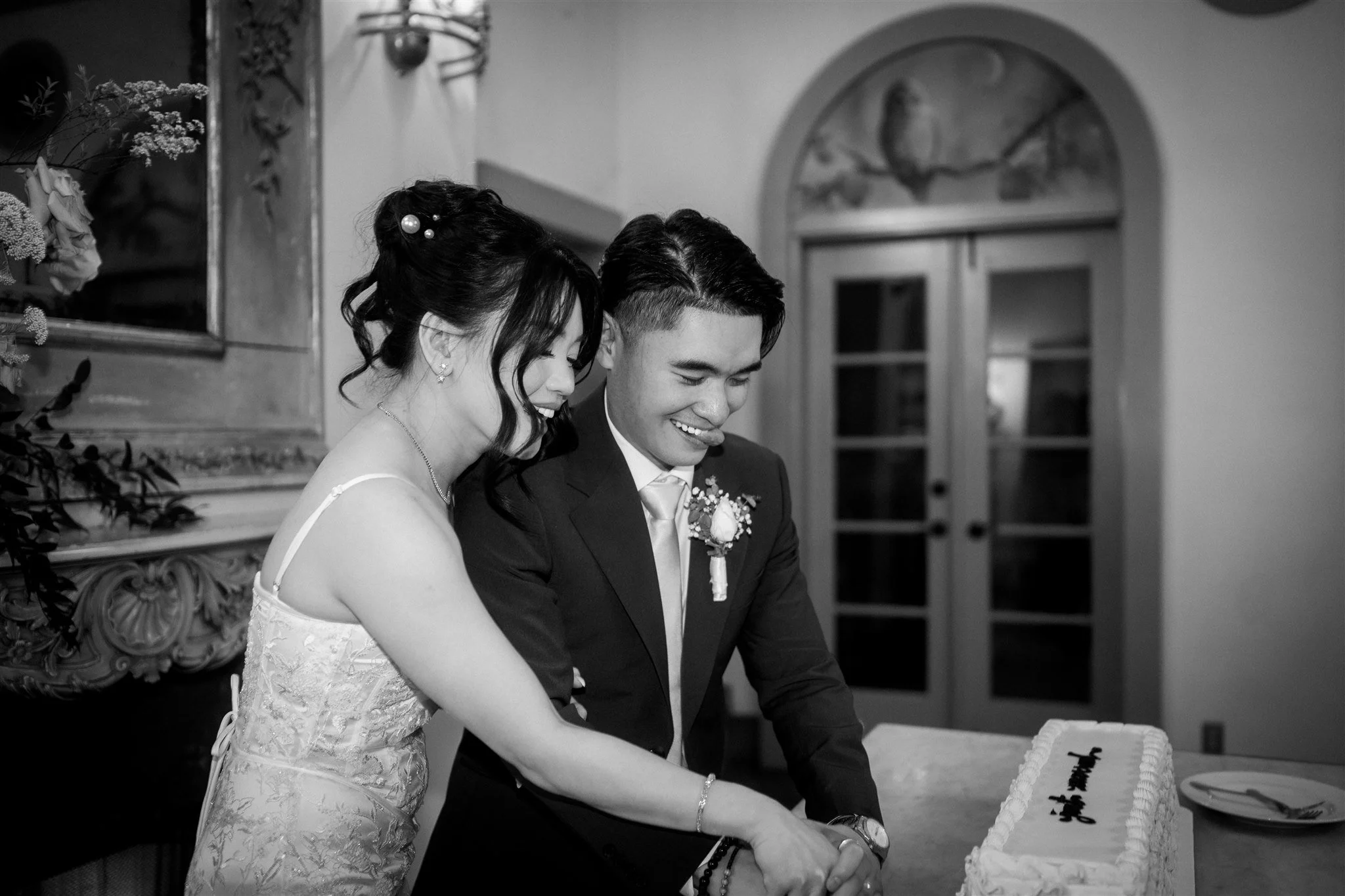 bride and groom cutting cake during their wedding reception at the ruins in seattle